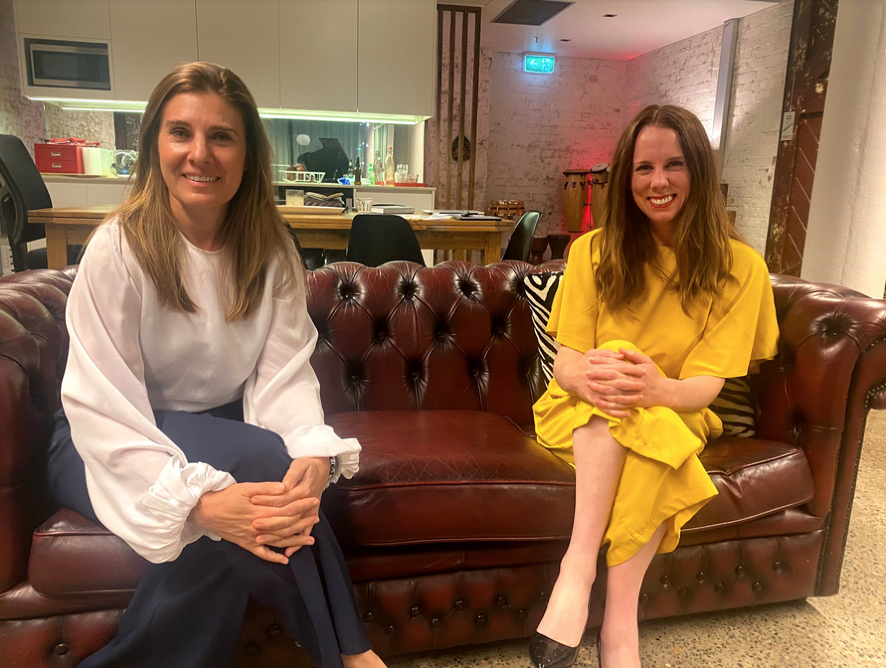 margot-faraci-gemma-fordham-smiling-seated-leather-sofa