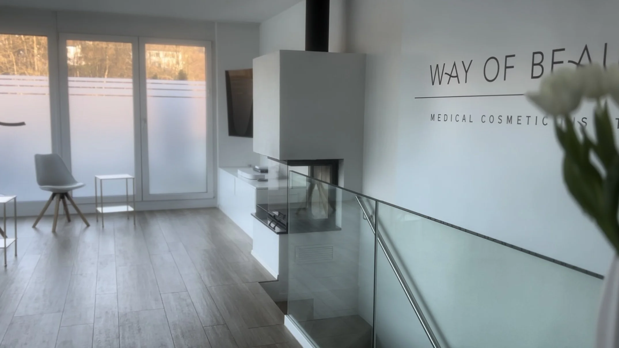 Empfangsbereich von Way of Beauty mit Cheminée und Blick zum Balkon