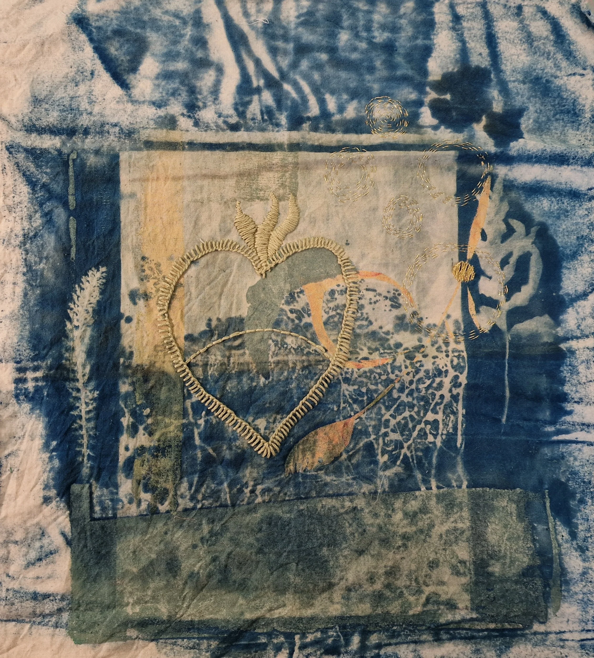 Sacred Heart 
Cyanotype on cotton, cotton thread. 
Cyanotype on Cotton using grasses and photographs printed onto acetate with screen printed shapes in background. Sacred heart symbol, a nod to the religious background of my family is stitched using 