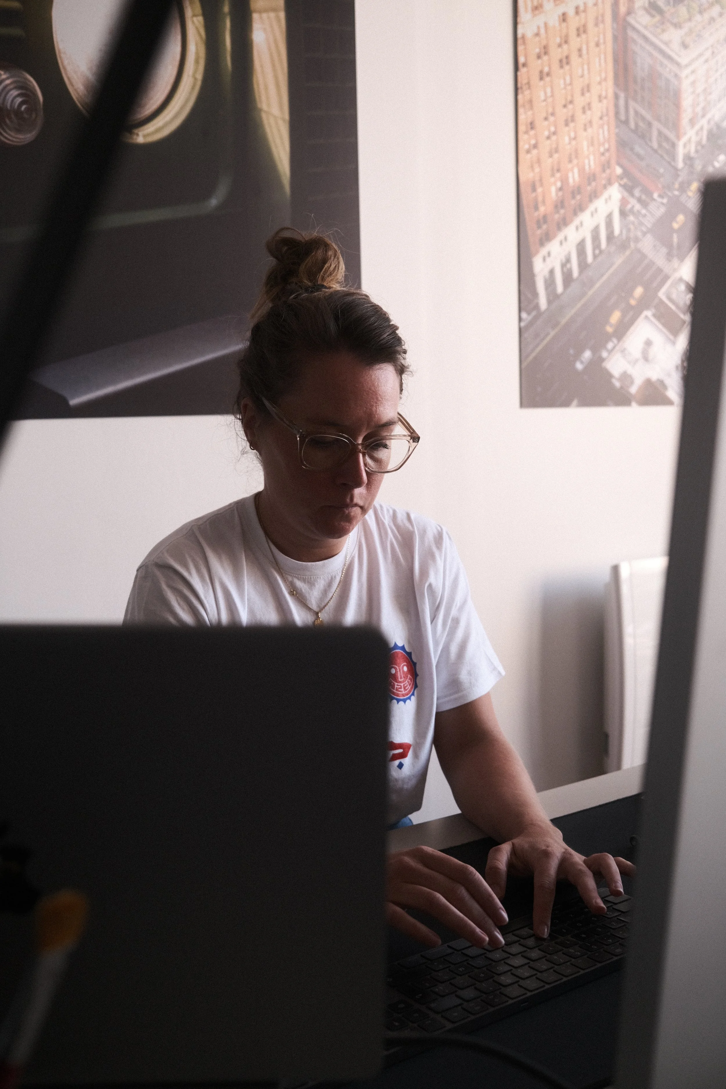 Personne tapant sur un clavier d'ordinateur dans un bureau avec des affiches en arrière-plan.
