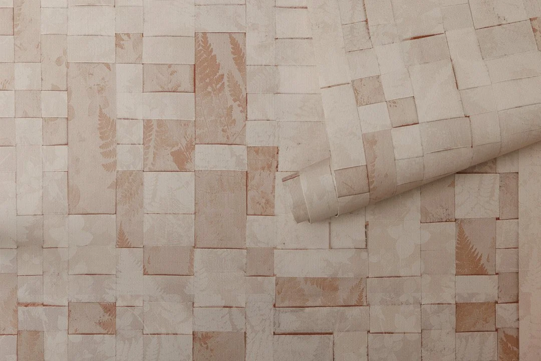 An unfurled roll of wallcovering with a sepia-toned woven botanical pattern.