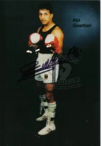 Junger Boxer in Sportkleidung mit Handschuhen, im Kampfposition, dunkler Hintergrund.