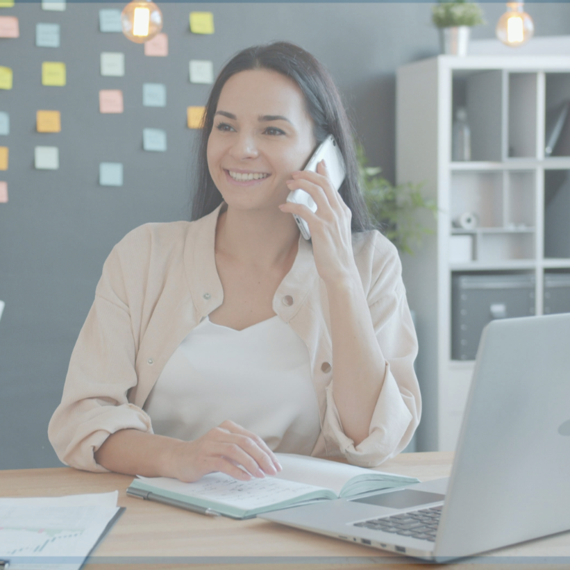 An IcebergIQ analyst conducting a win-loss interview with a B2B customer at her desk with an open laptop and a notebook.