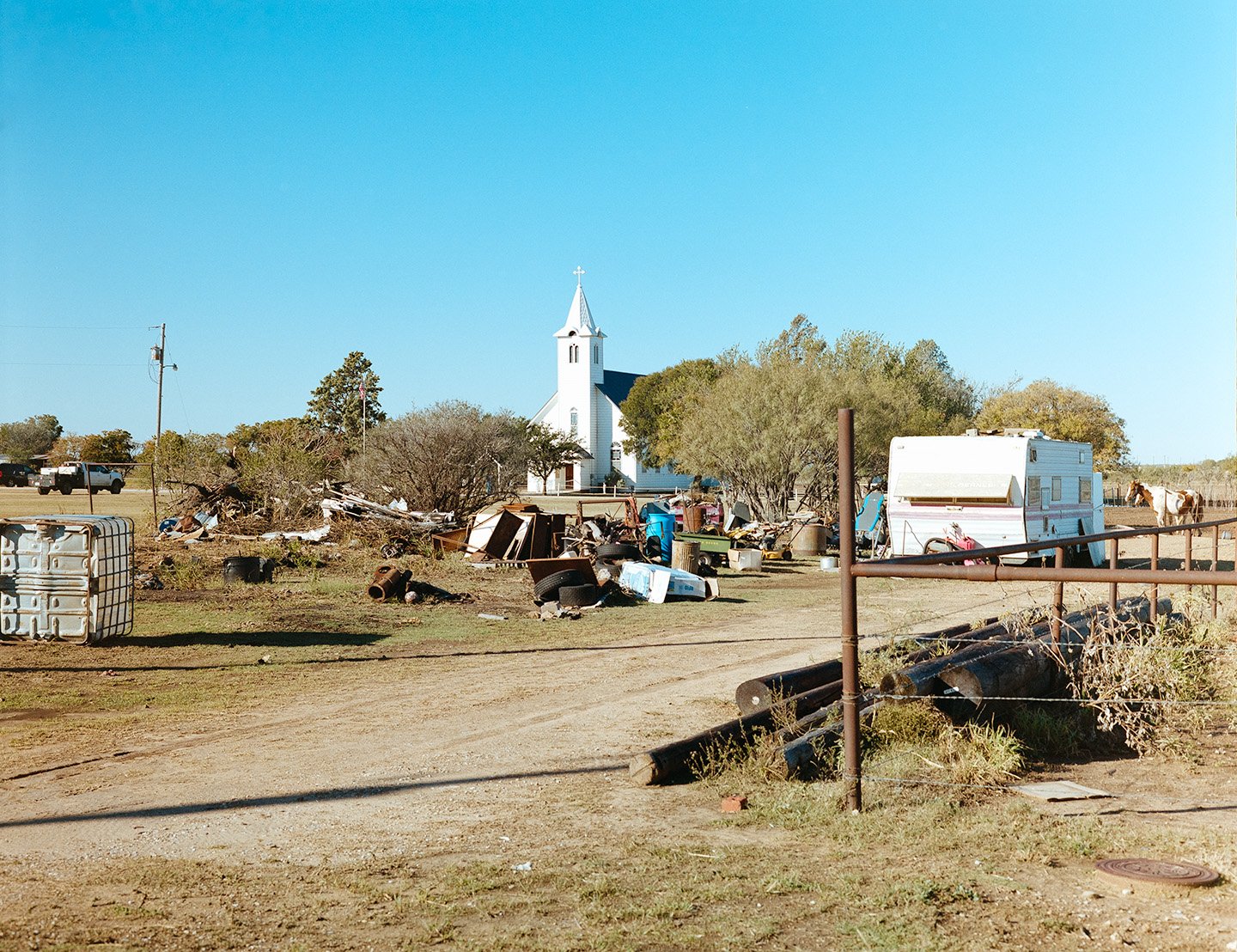 Megargel, Texas. Old western Catholic Church in a west Texas field surrounded by trash.