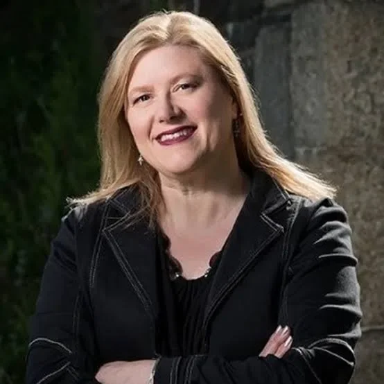 Blond woman wearing a blazer.
