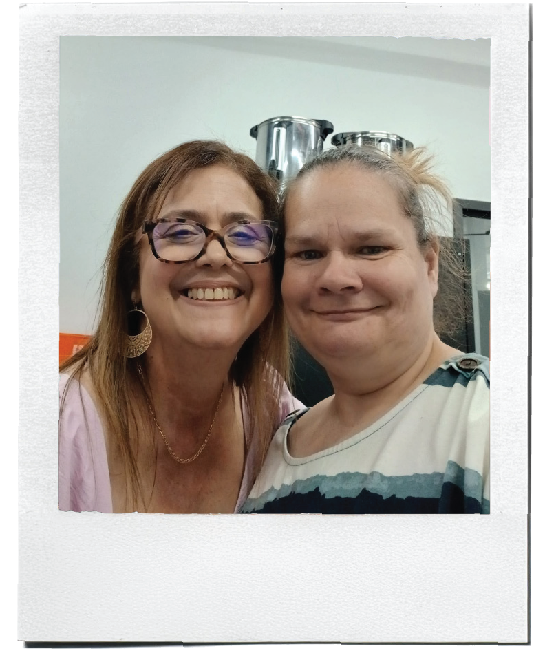 Polaroid-style picture of two people smiling while posing for a photo indoors.