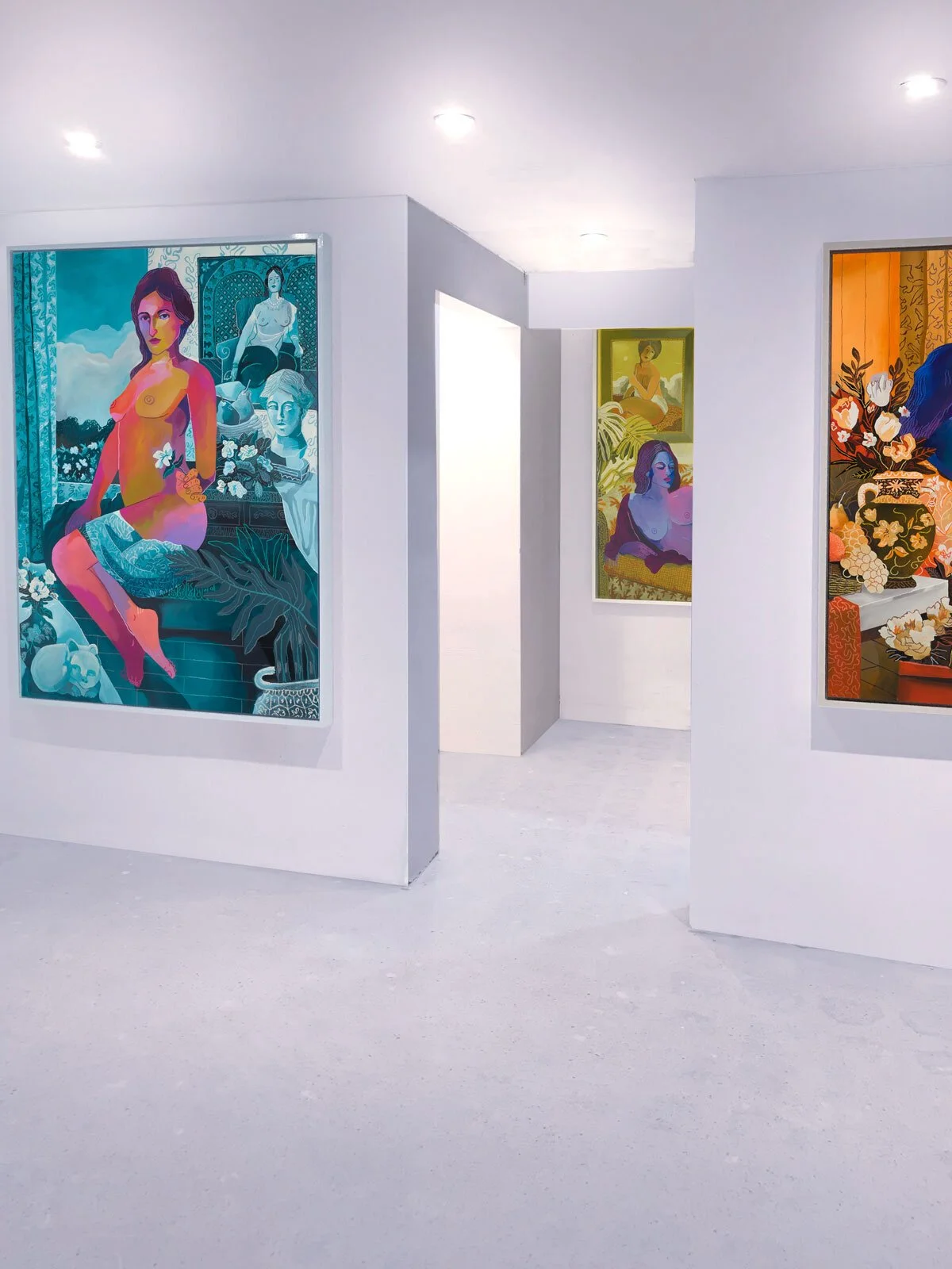 Gallery with colorful paintings of women on white walls, brightly lit with ceiling lights.