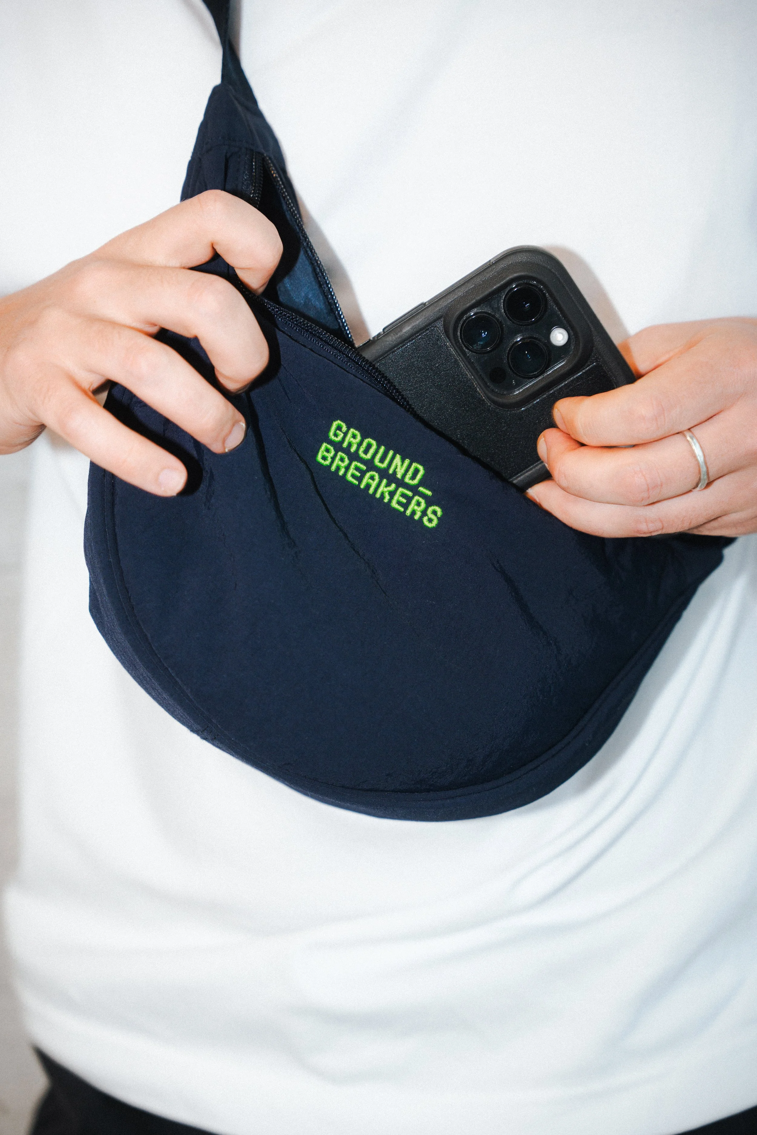Dunkelblaue Tasche mit neongrünem Schriftzug "Groundbreakers"