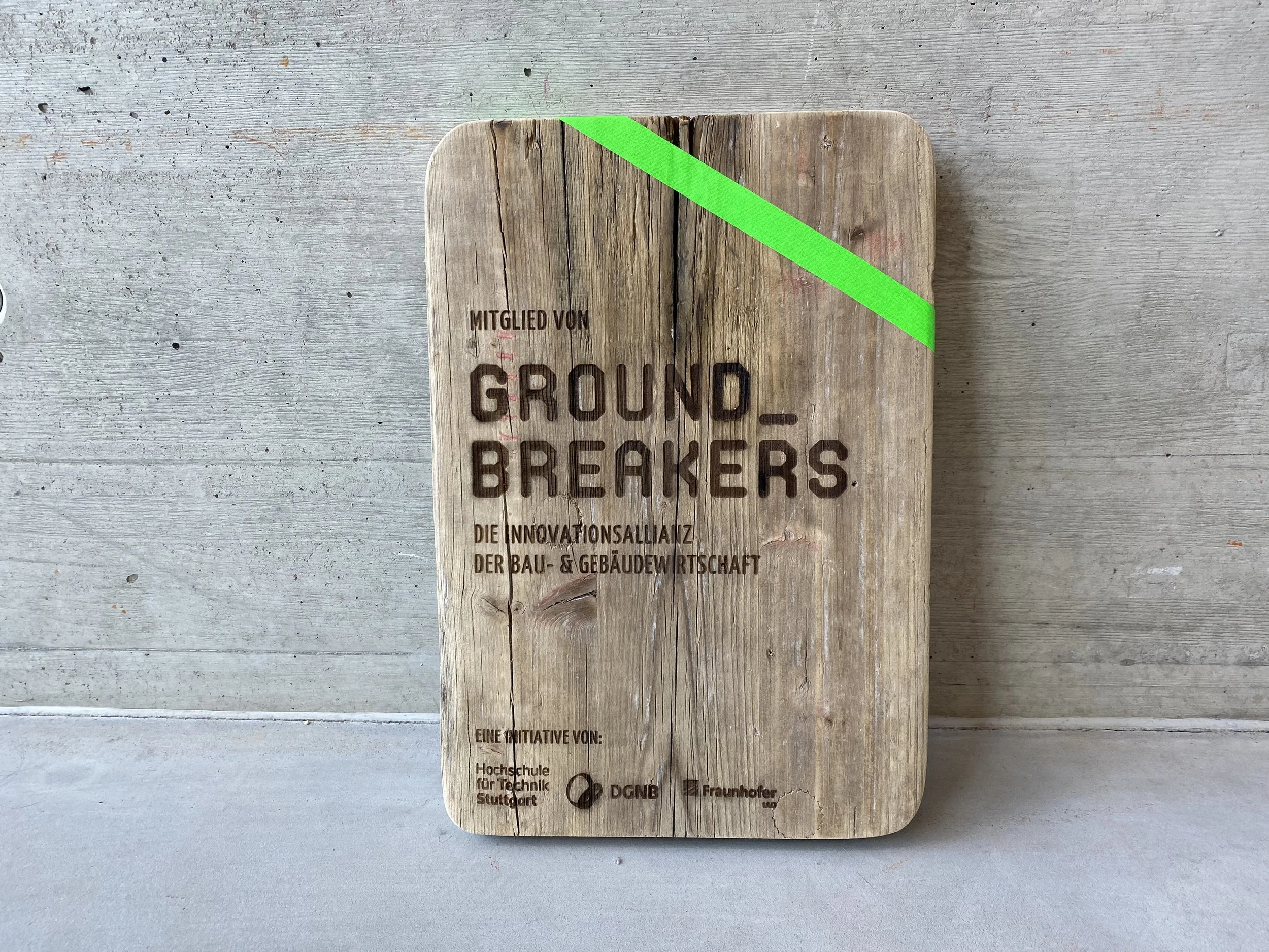 eine alte Gerüstbohle als Mitgliedsplakette von GROUNDBREAKRES