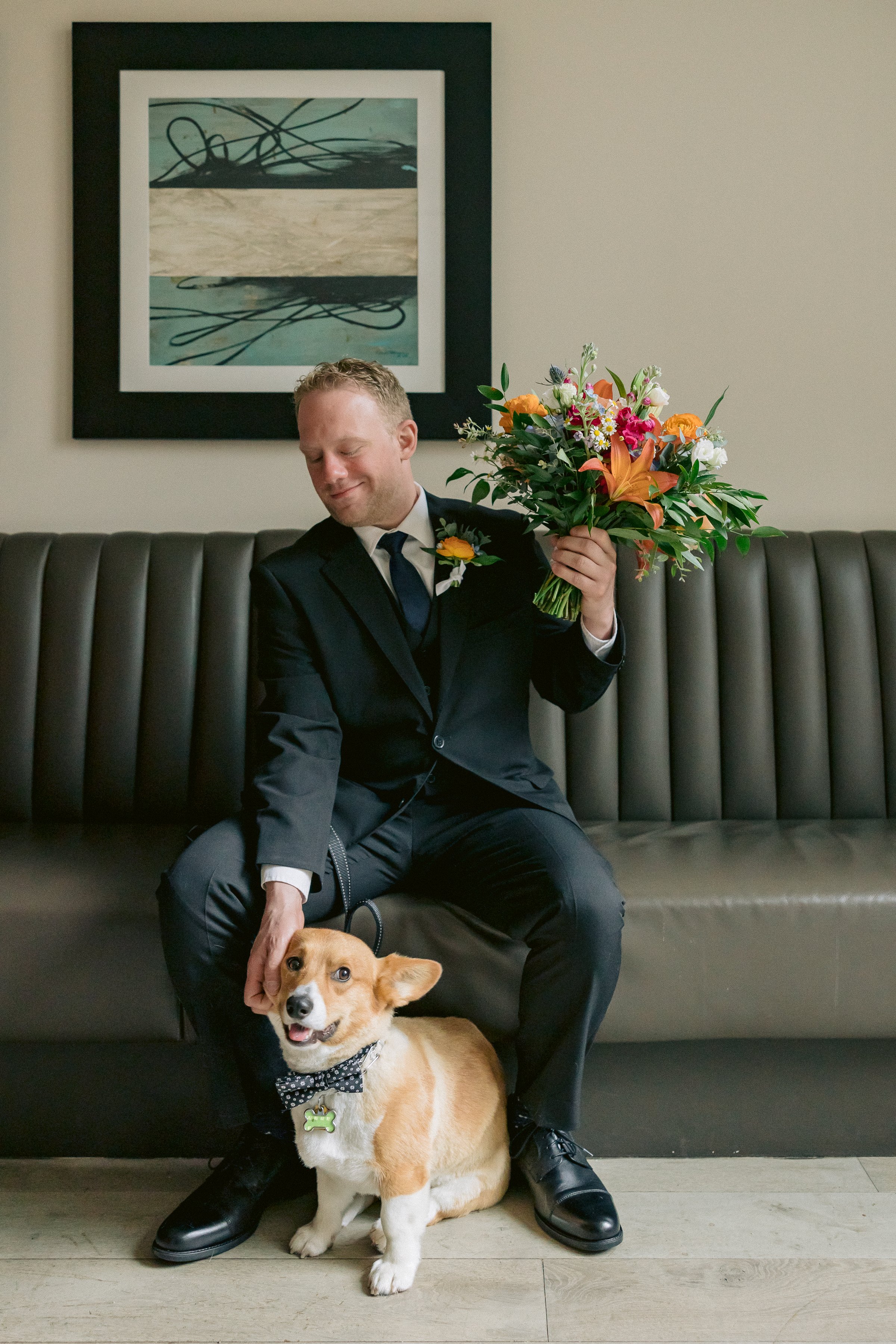 groom with his dog poses for wedding photos
