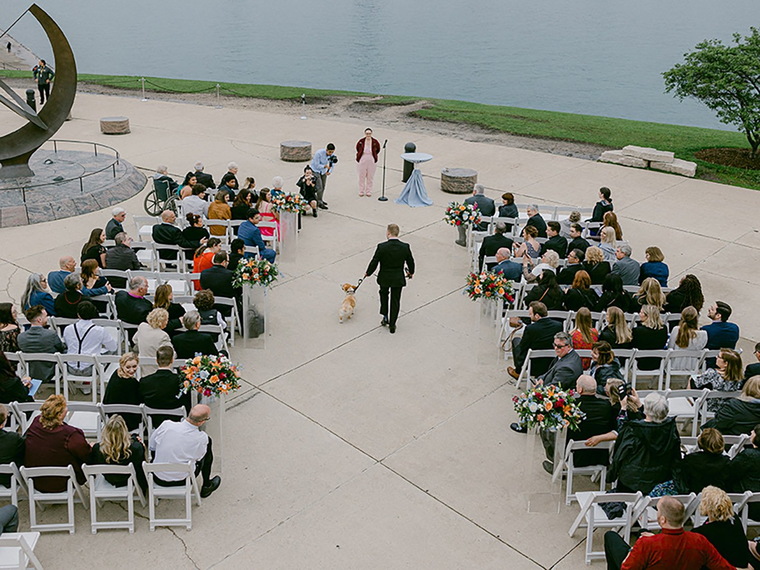 groom walks down the aisle with his dog