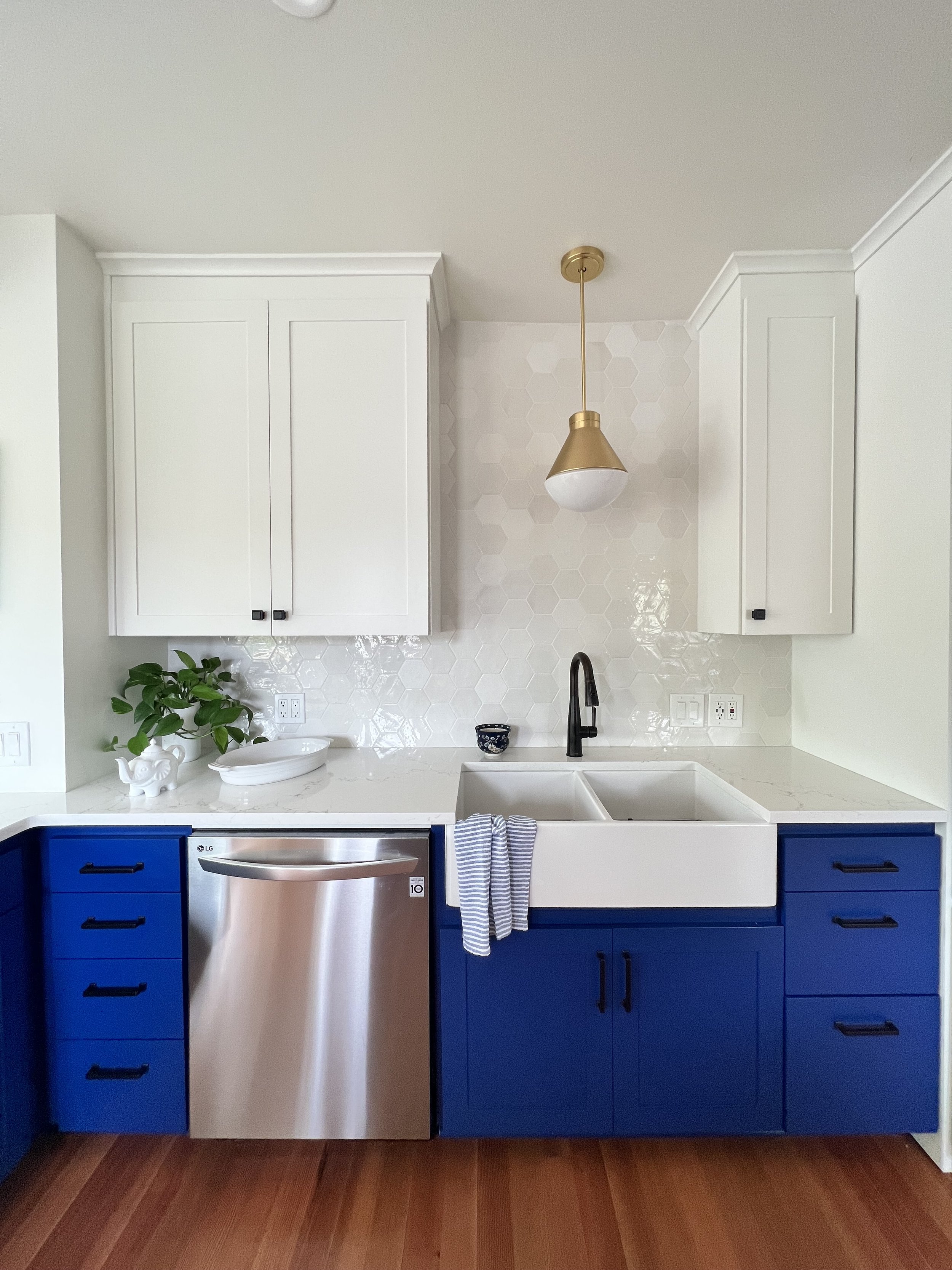 Clean white upper cabinetry and gold hardware details over a sink in a University Place kitchen remodeling project.