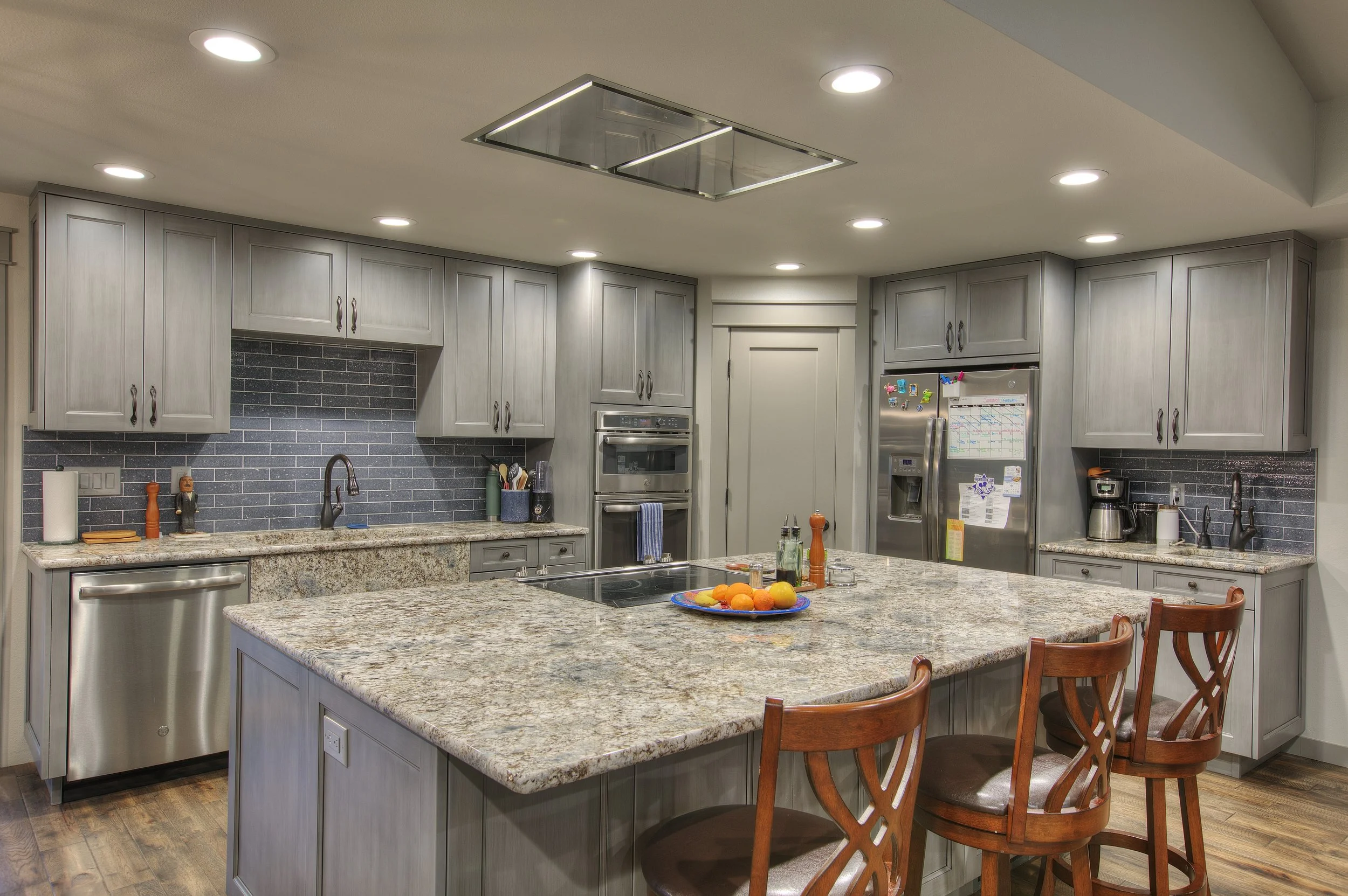 Open kitchen design featuring custom wood cabinetry and stone countertops in Tacoma.