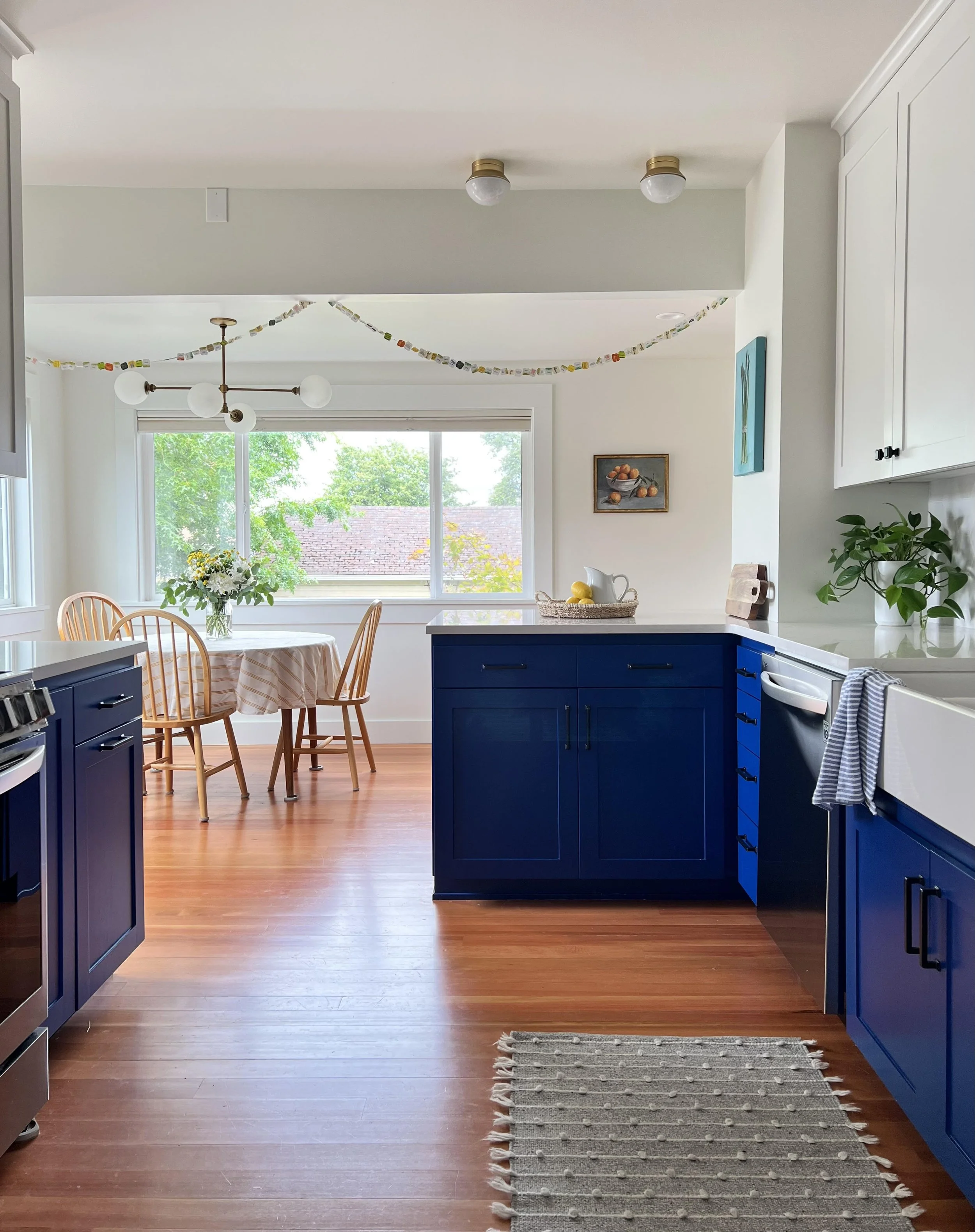 Open concept kitchen and dining room remodel showcasing two-tone cabinetry and bright natural light in Gig Harbor.