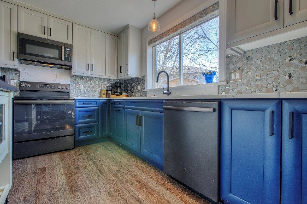 Custom blue lower cabinets and stainless steel appliances in a luxury Gig Harbor kitchen renovation.