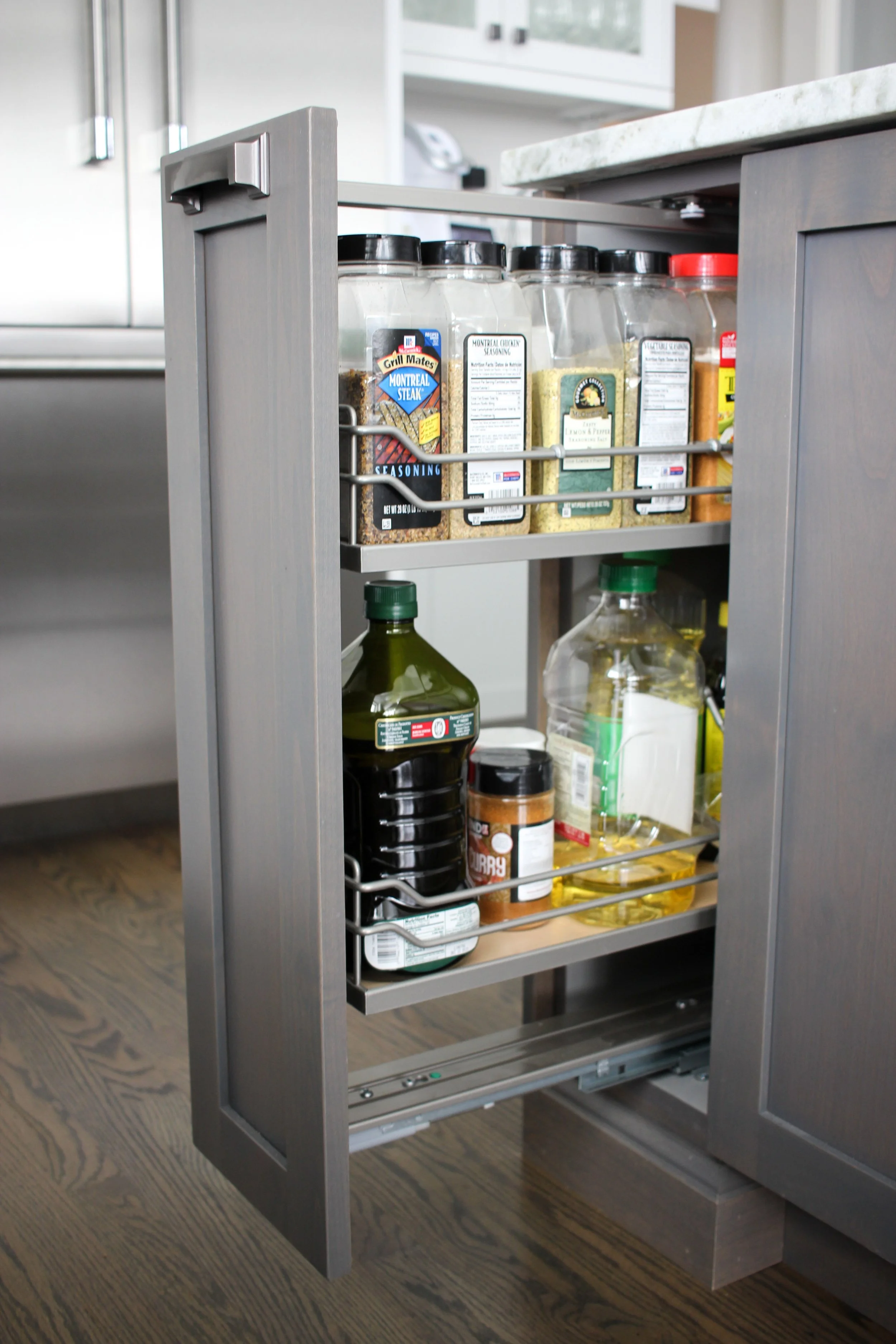 Built-in spice rack pull-out next to the range in a Gig Harbor kitchen remodel.
