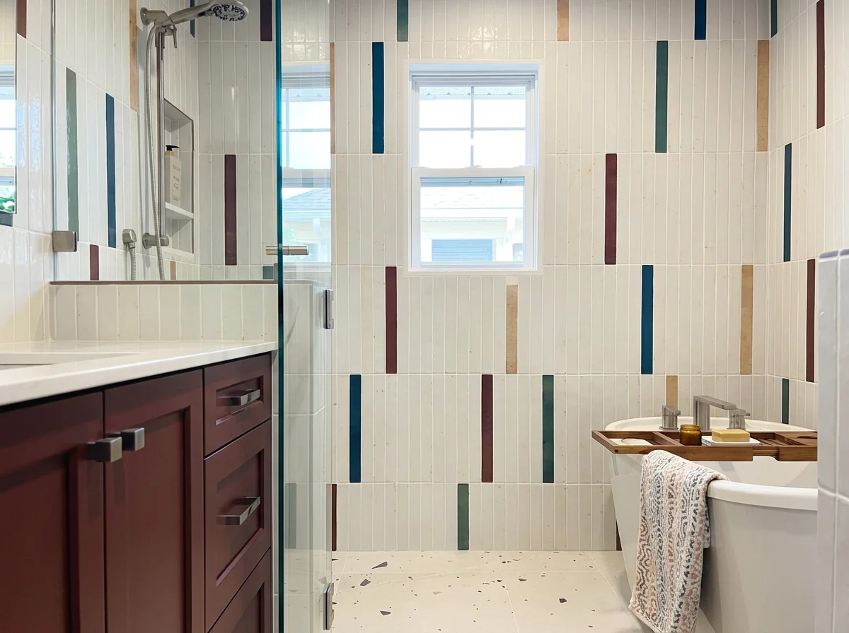 Modern bathroom design with a glass walk-in shower and bold colorful wall stripes in Pierce County.