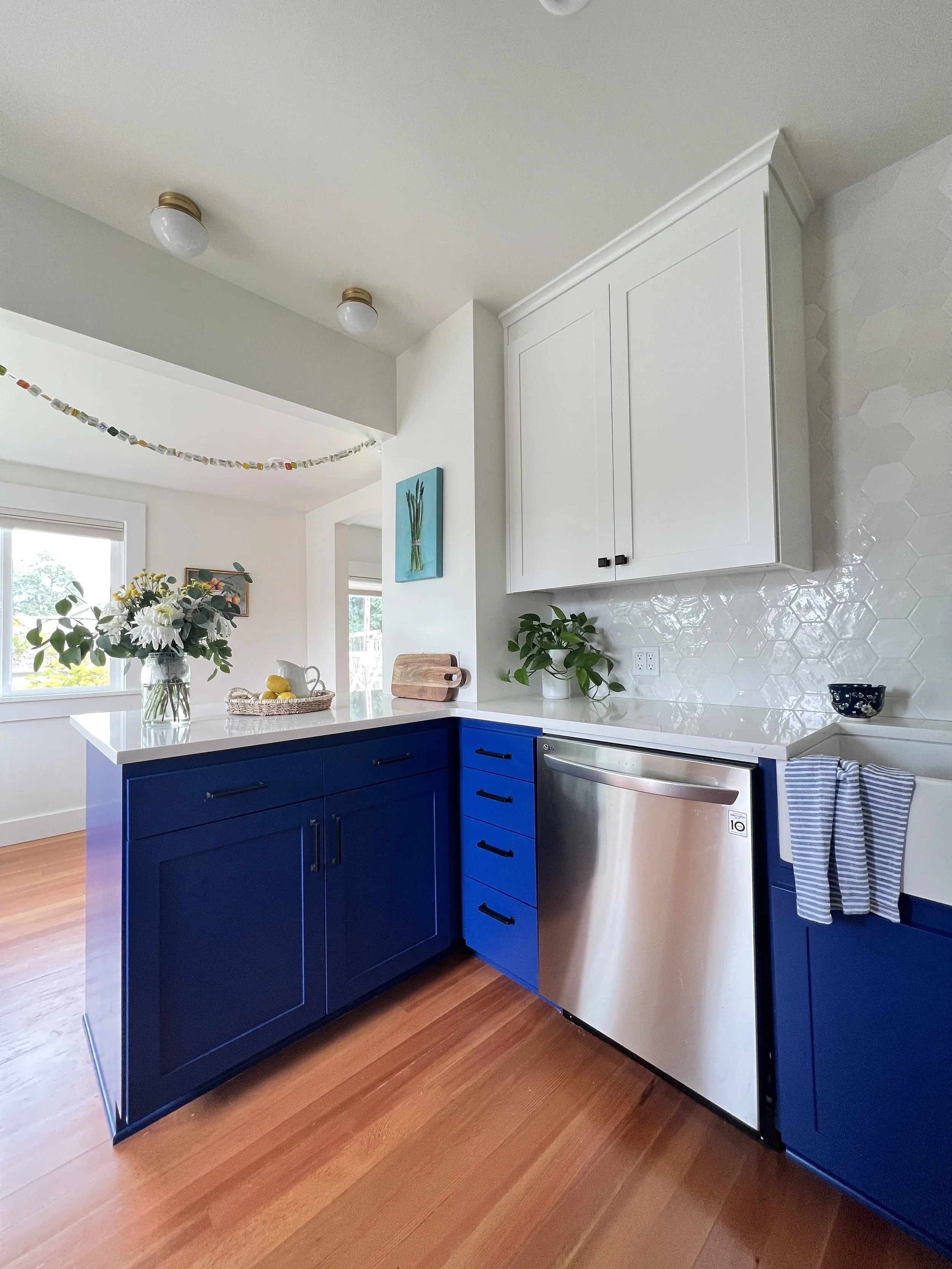 Two-tone kitchen design featuring white upper cabinets and striking blue lowers in a Pierce County home renovation.