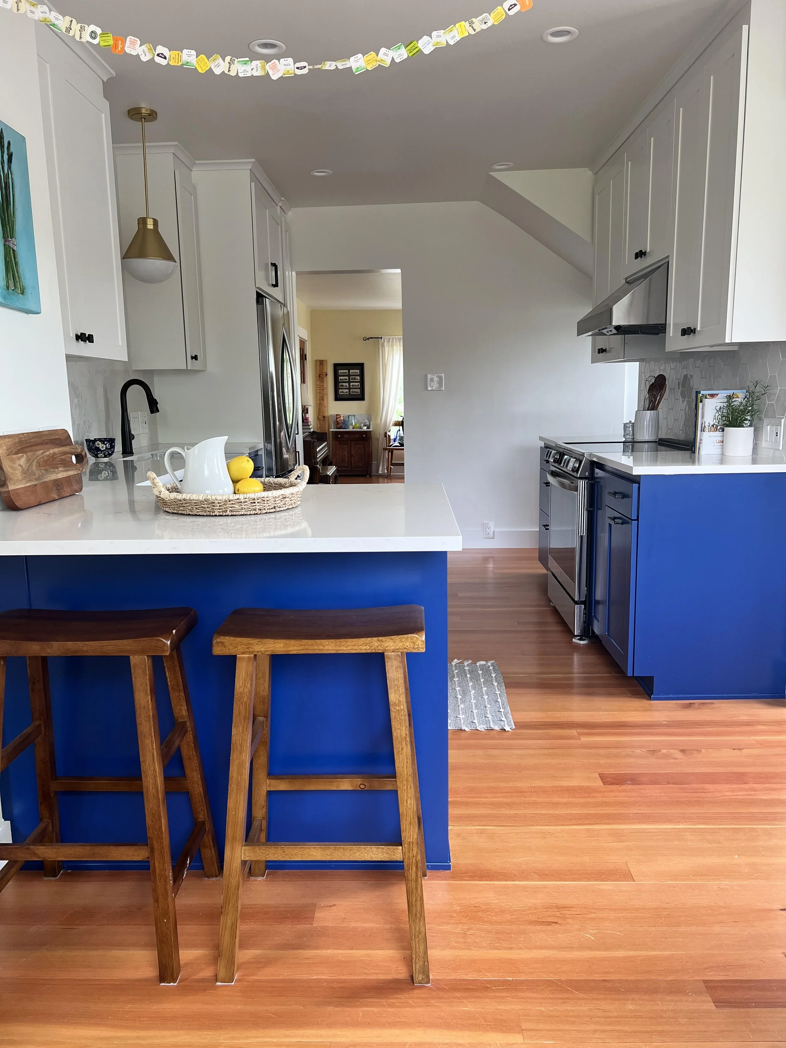 Wide view of an open-layout kitchen featuring a custom blue peninsula from the living area in a Puget Sound home.