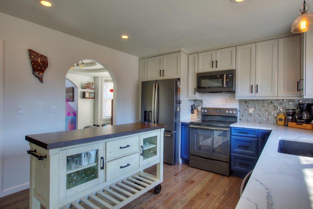 Custom kitchen remodel featuring a white center island and arched doorway in the Puget Sound region.