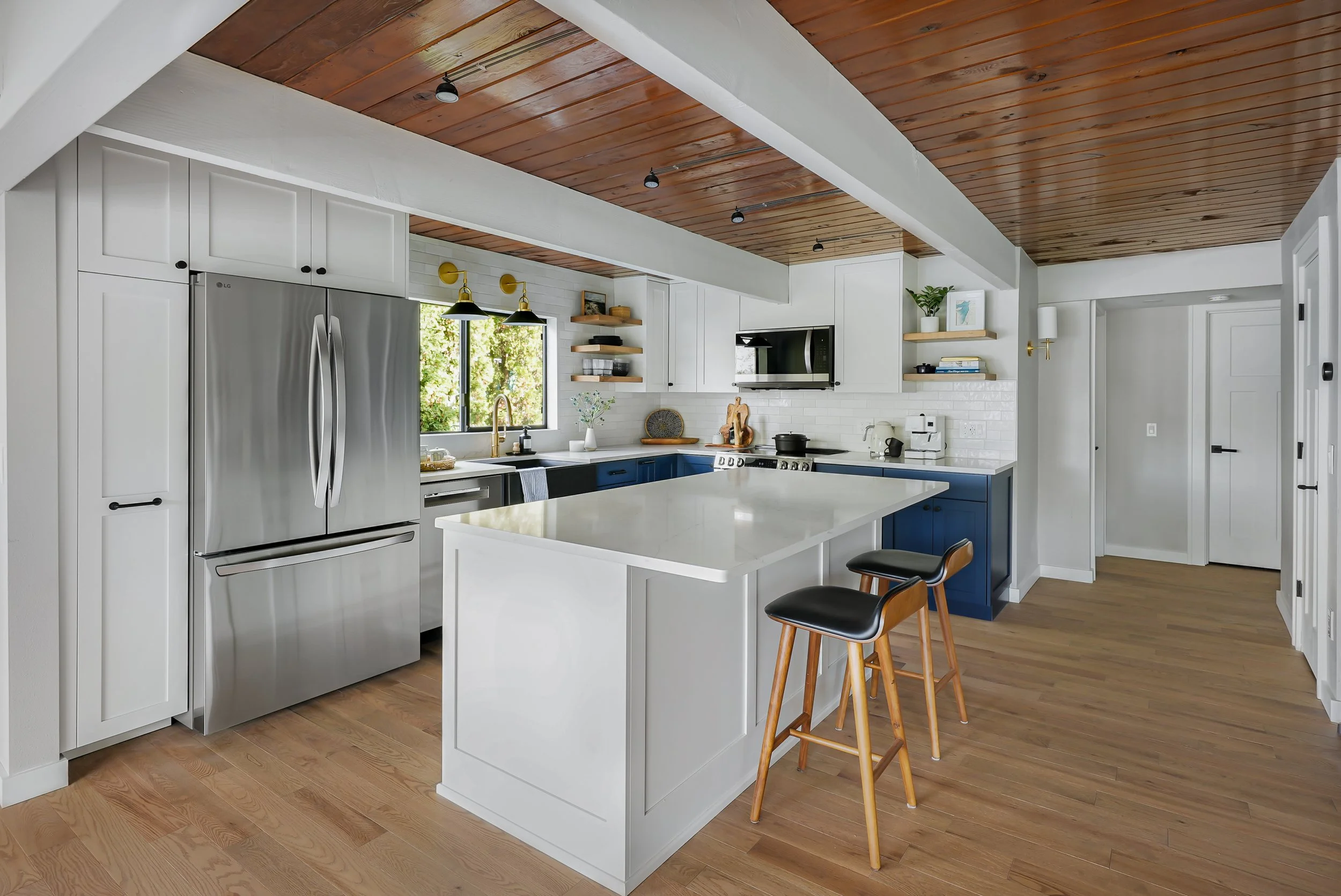 Large kitchen island with bar seating and navy blue lower cabinets in Pierce County.