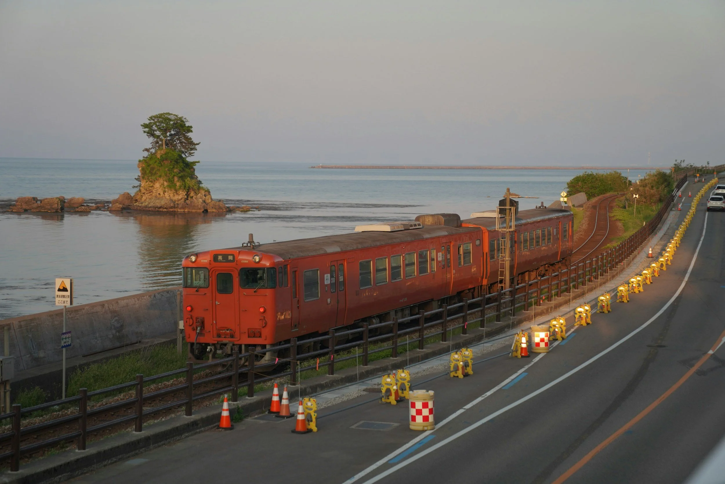 Red train moving along the coast
