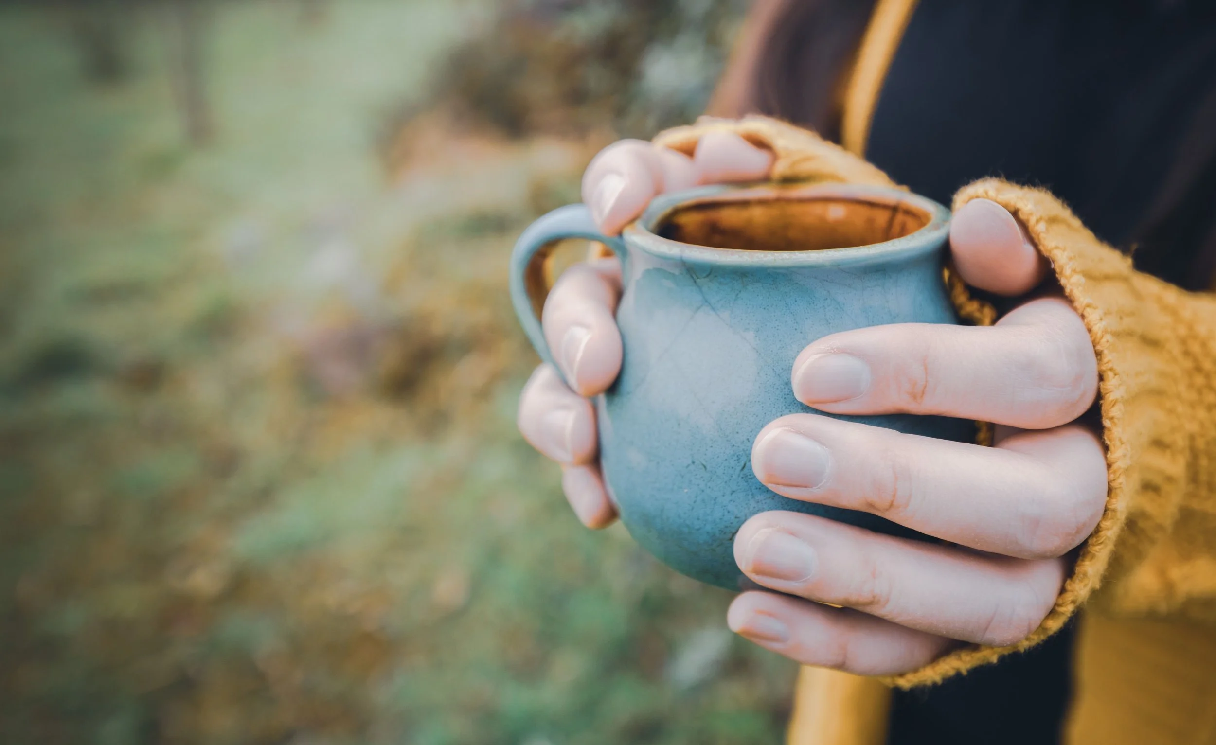 woman holding coffee fall background