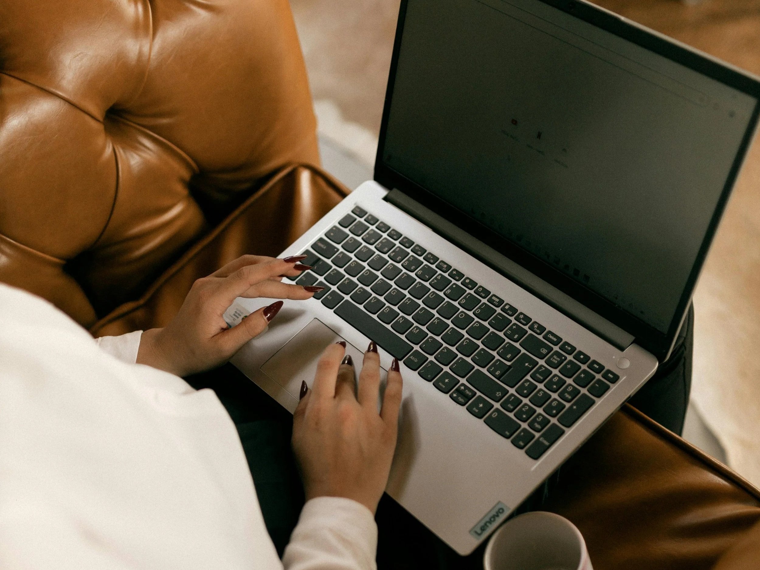 woman with red nails typing on laptop