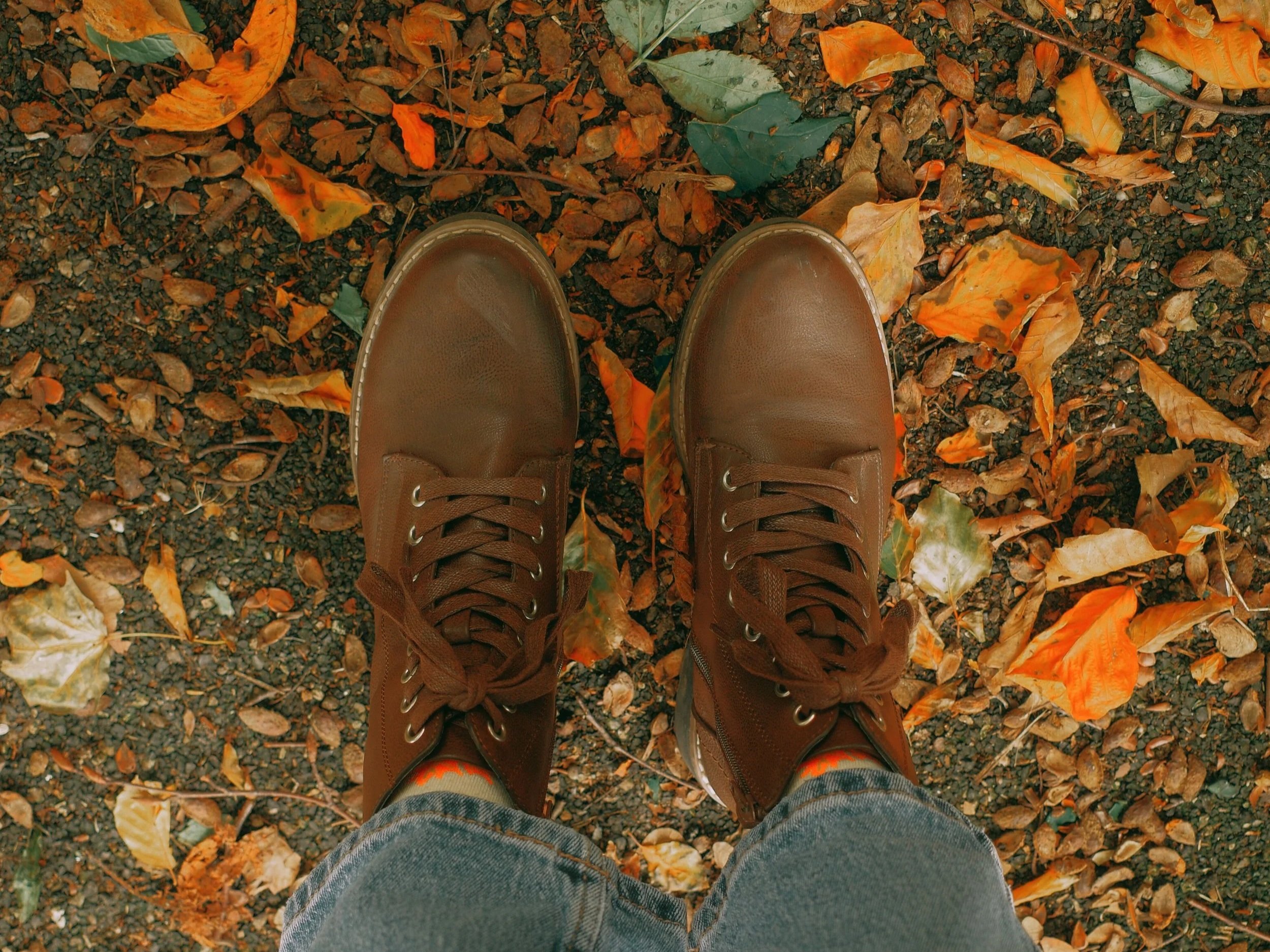 brown boots standing in fall leaves
