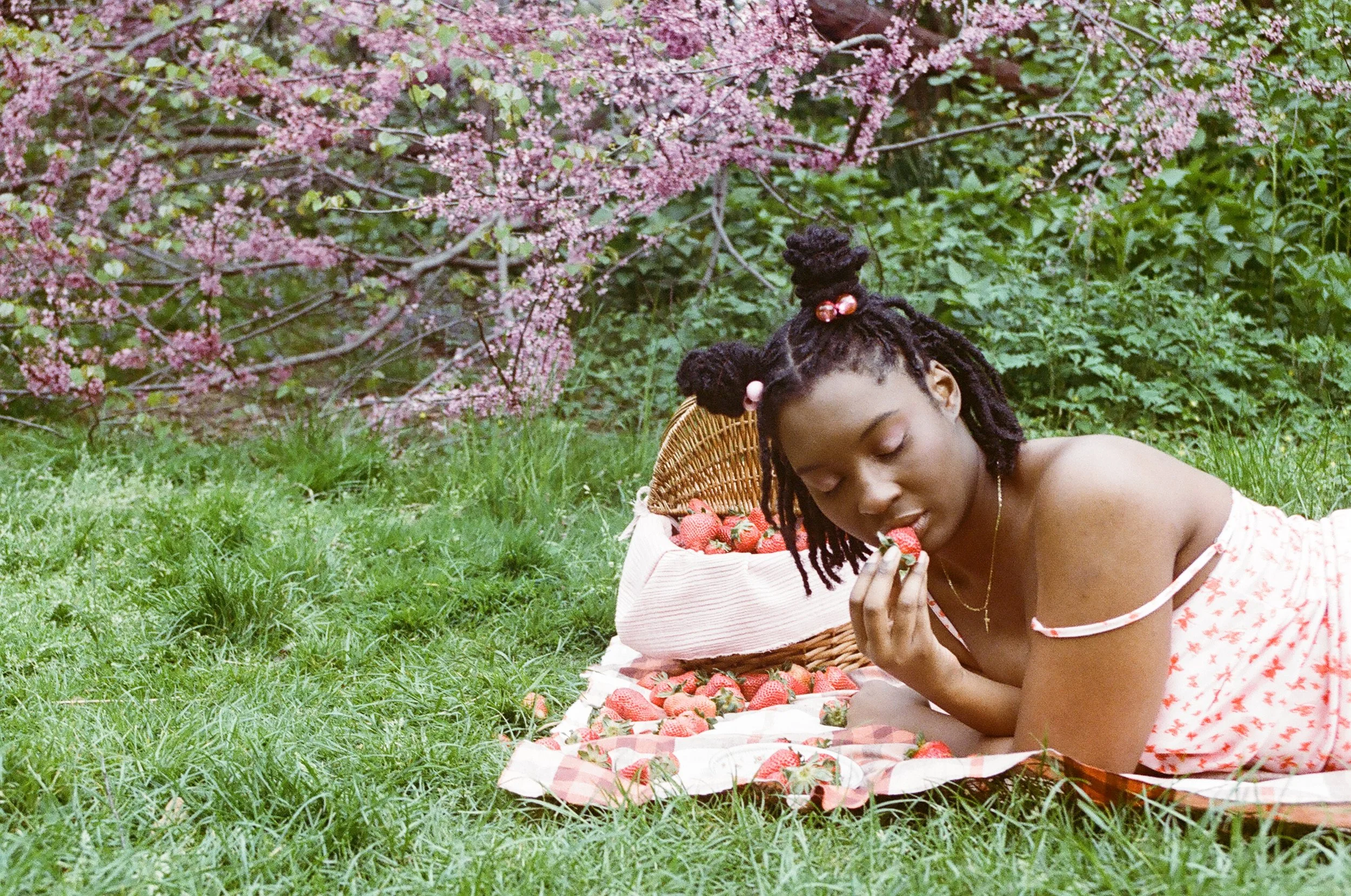 woman eating strawberries in field