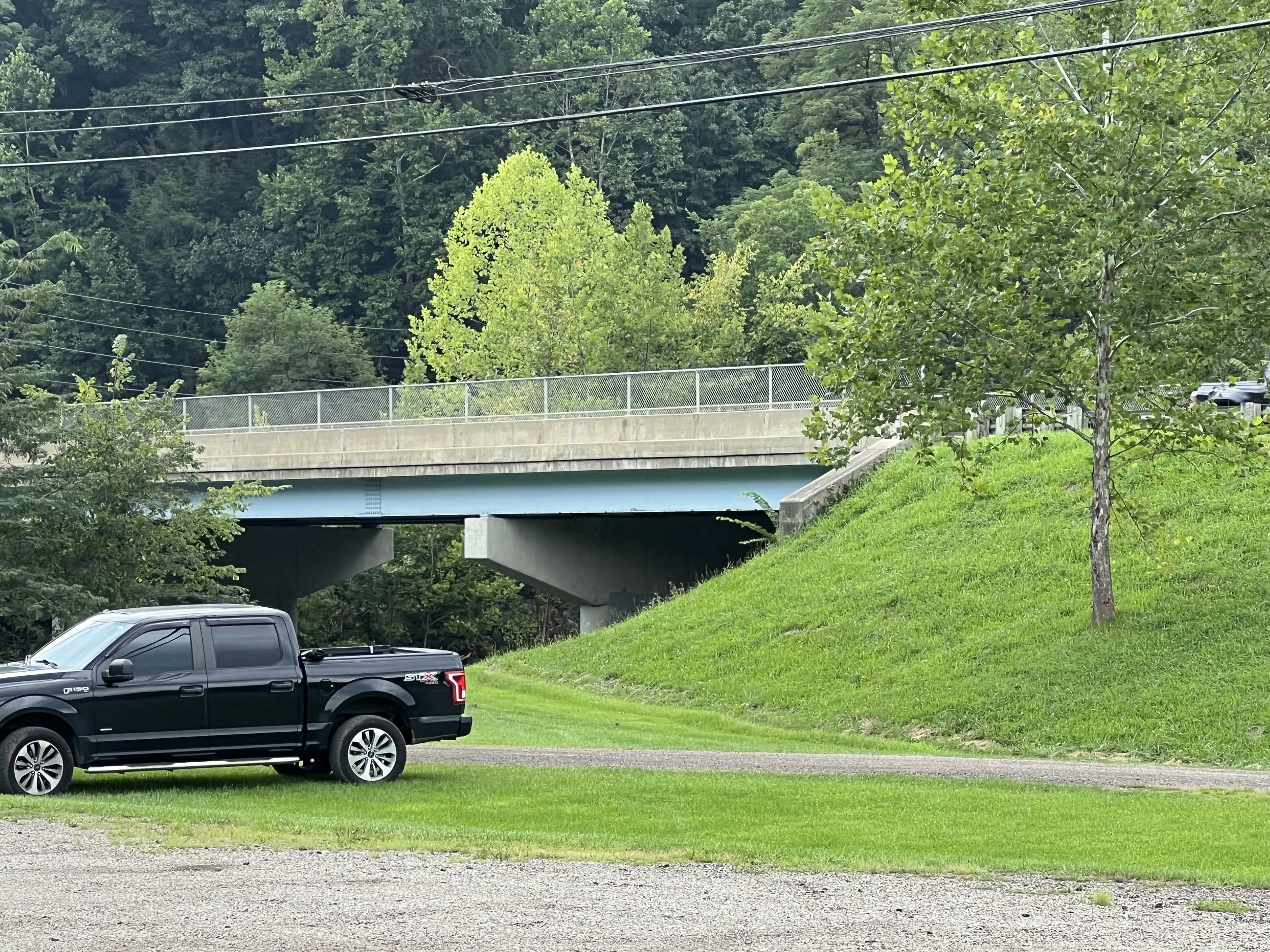 Ride under the overpass to the paved road and trail entrance.