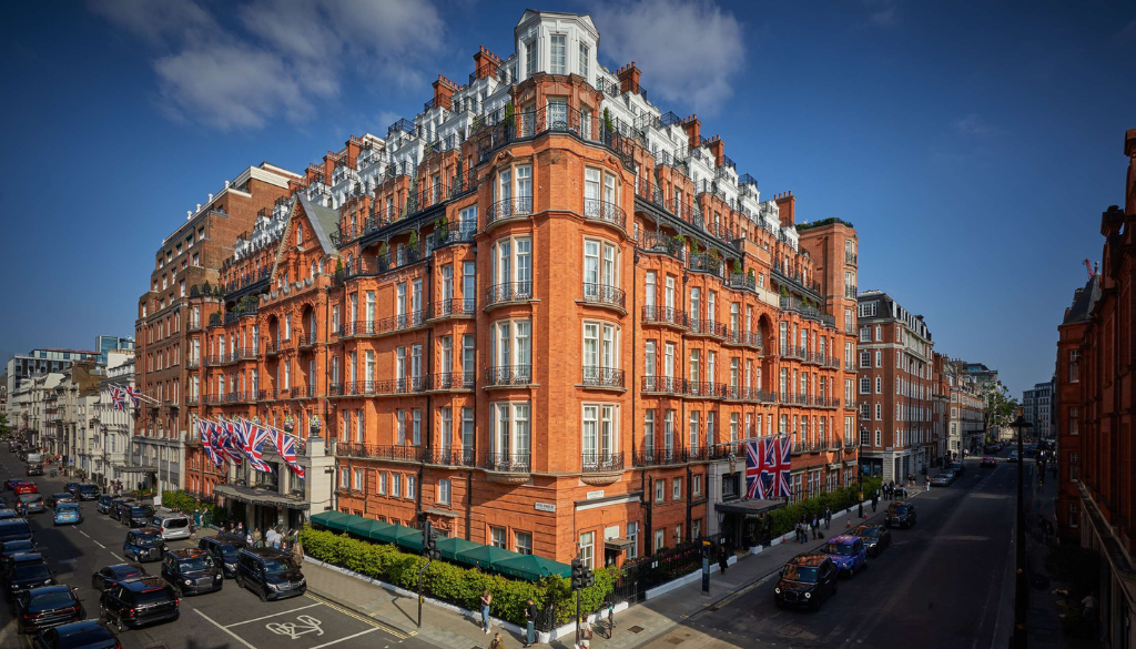Grand art deco entrance of Claridge's hotel in Mayfair London decorated for Christmas with festive wreaths and doorman in livery