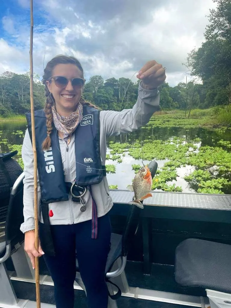 Luxury Aqua Nera river cruise vessel sailing through the Peruvian Amazon at sunset surrounded by dense rainforest