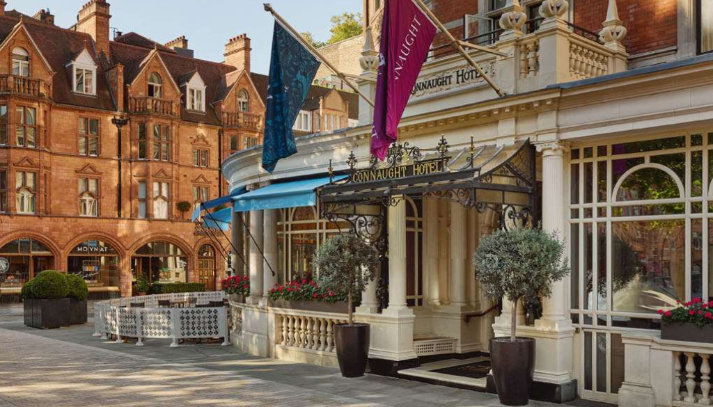 Elegant facade of The Connaught hotel in Mayfair London with classic red brick architecture and refined entrance in the heart of the city