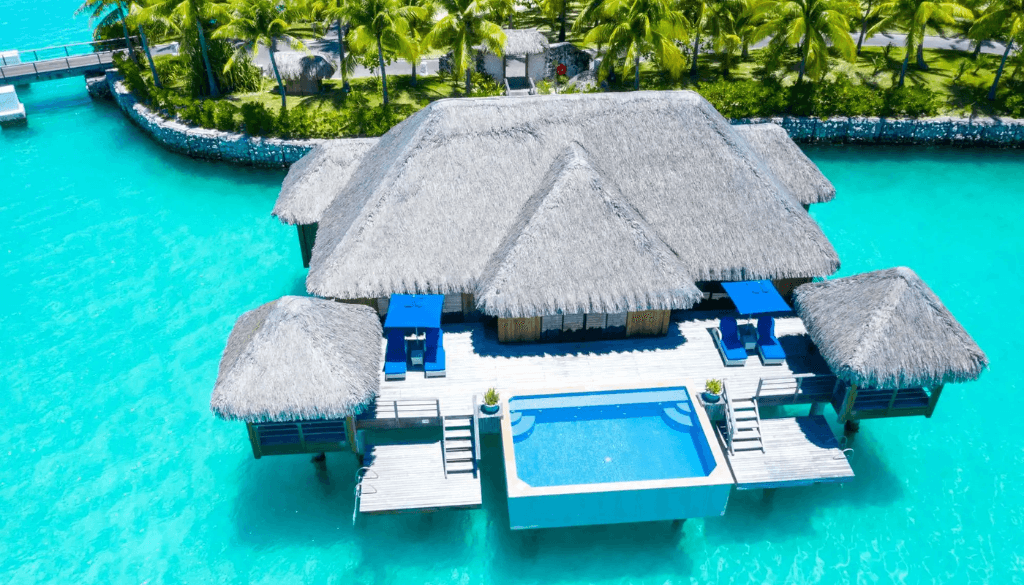 Overwater premier suite villa at The St. Regis Bora Bora Resort with glass floor panels, private terrace, and turquoise lagoon views