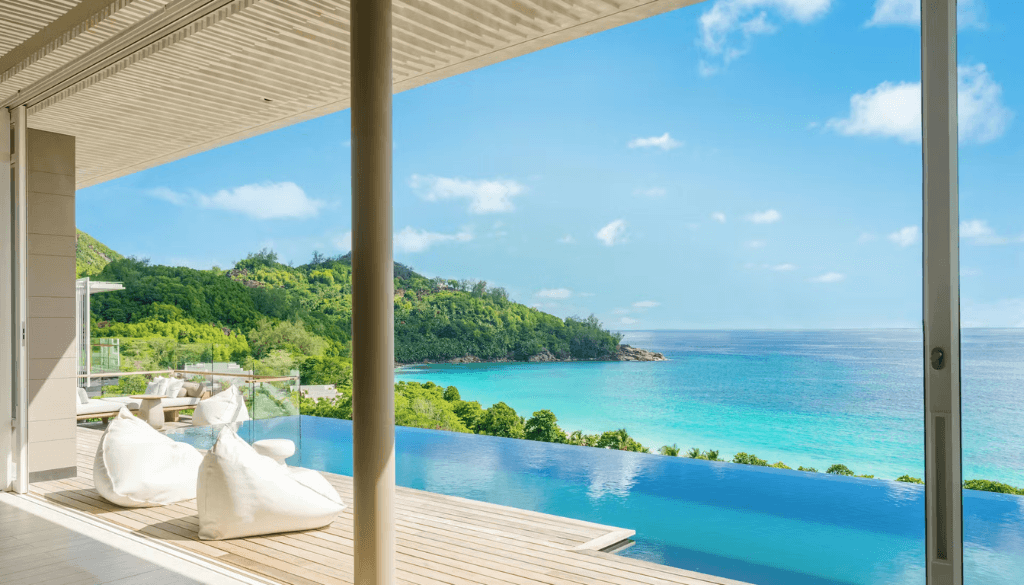 Luxury ocean view suite at Cheval Blanc Seychelles with contemporary interior design, floor-to-ceiling windows, and sweeping Indian Ocean panorama