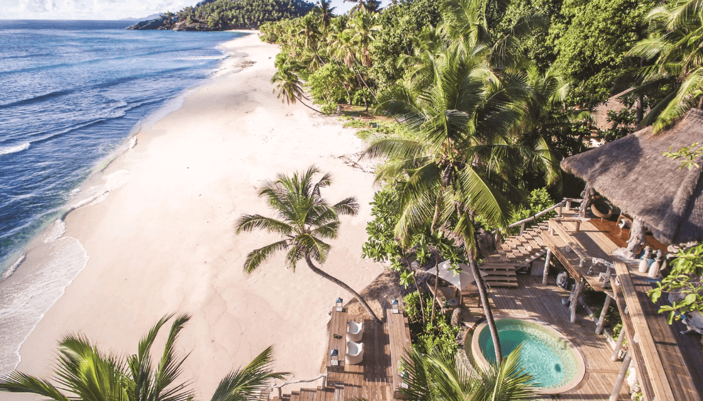 Aerial view of North Island private resort in the Seychelles with lush jungle interior, pristine white sand beaches, and turquoise lagoon on all sides