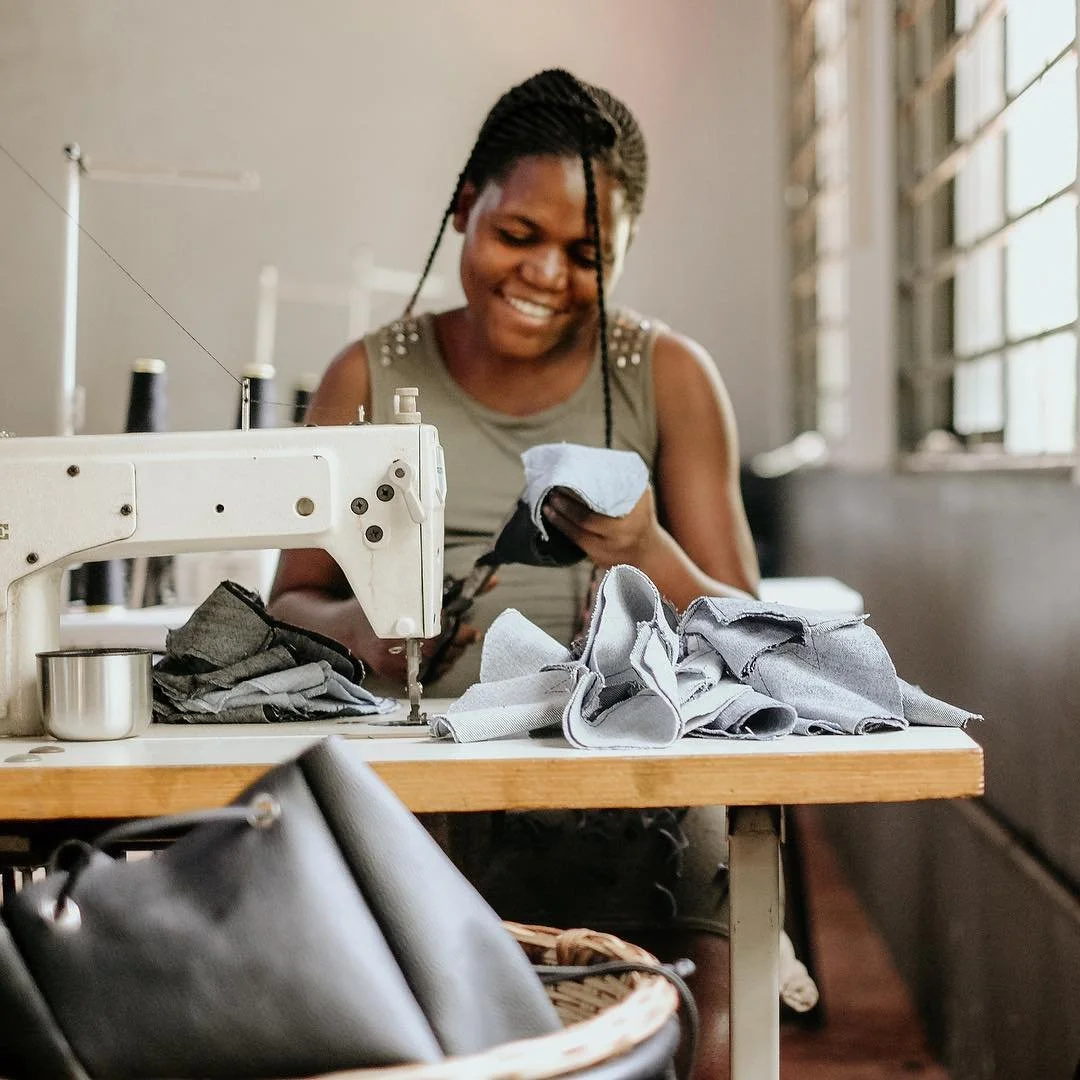 Ugandan tailor sewing Sole Hope shoe uppers as part of long-term employment