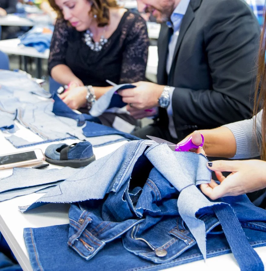 Corporate team building with Sole Hope, cutting denim together