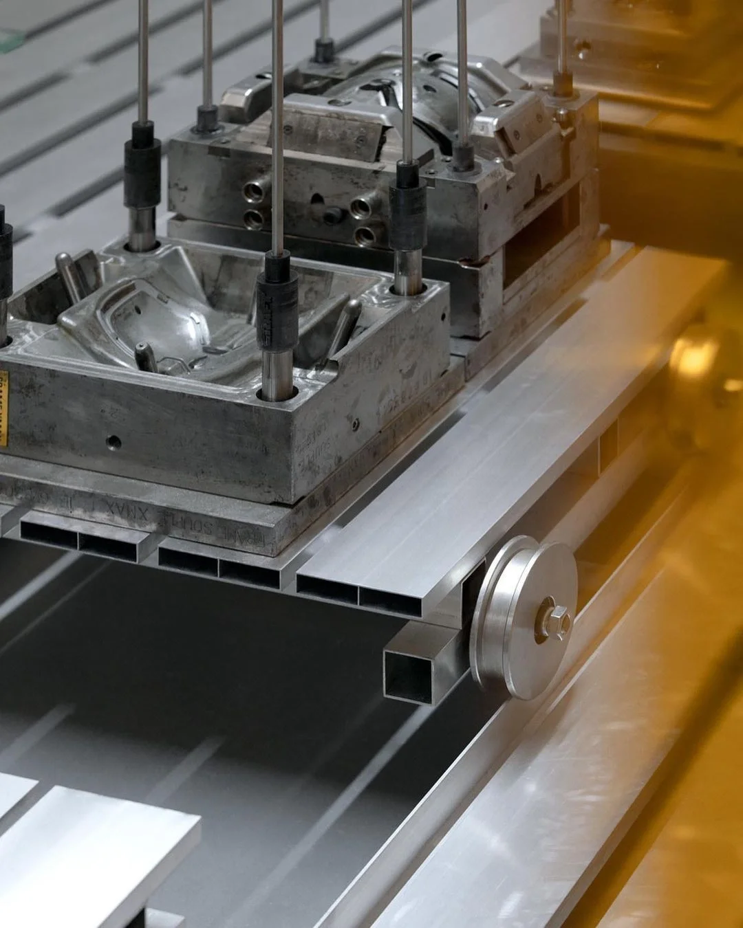 Steel injection mold tooling mounted on a machine bed