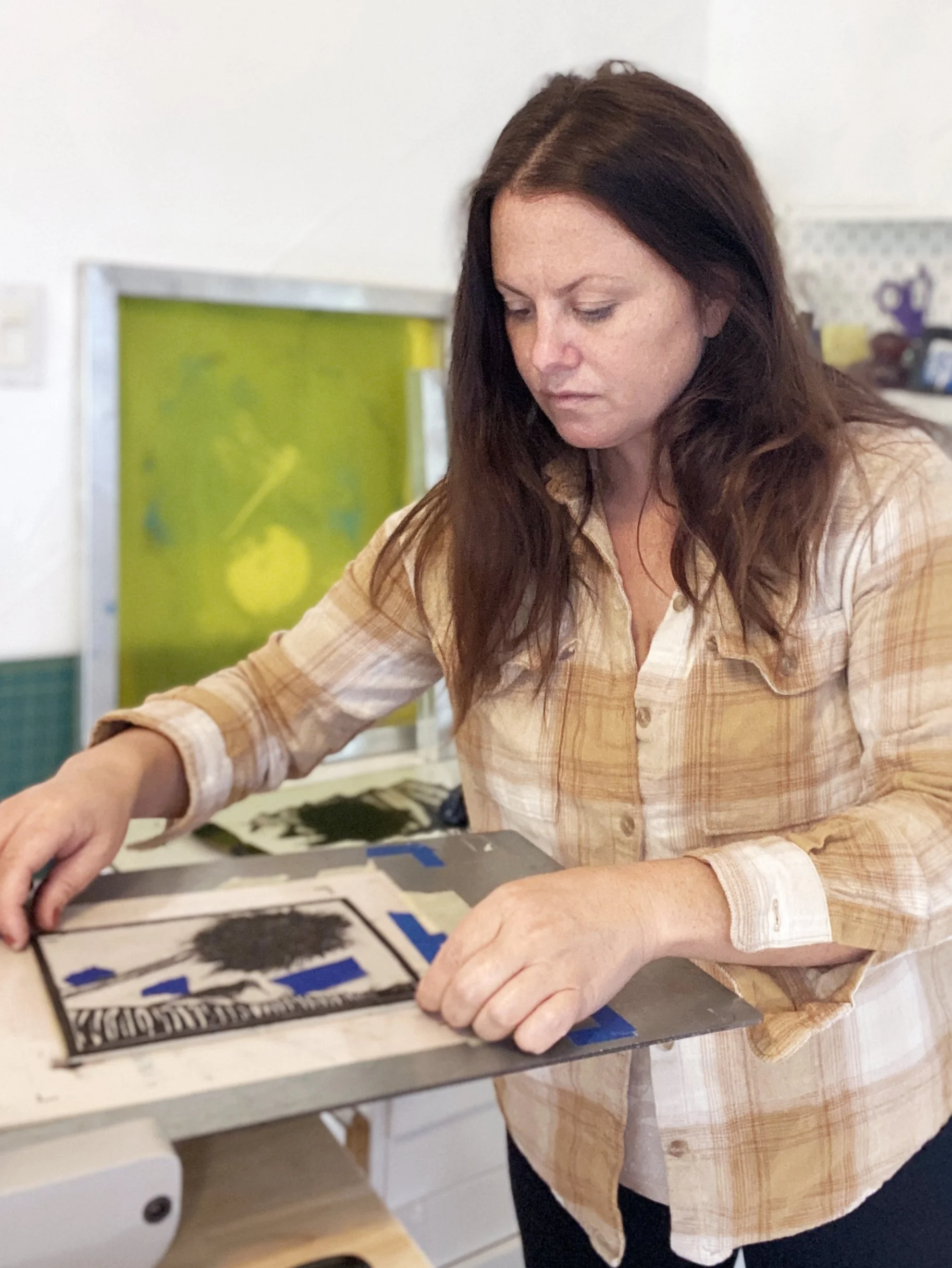 Hanna Clark positioning a linocut block on her printing press
