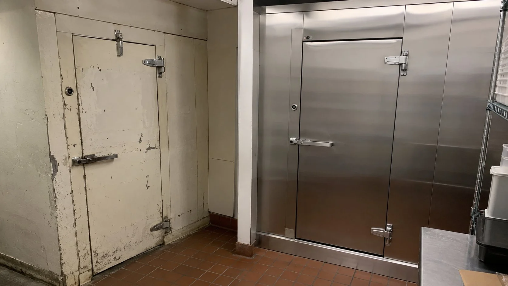 Older walk-in cooler panels beside a new stainless walk-in cooler build