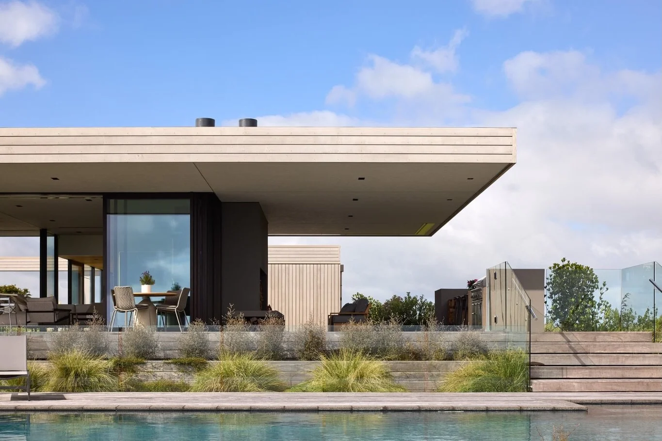 FRAMED BY PASTURE AND SEA 

Set on an expansive rural site in Mangawhai, this beautifully considered home by Studio John Irving captures sweeping views across rolling pasture to the distant Hen and Chicken Islands.

Designed to feel deeply connected 