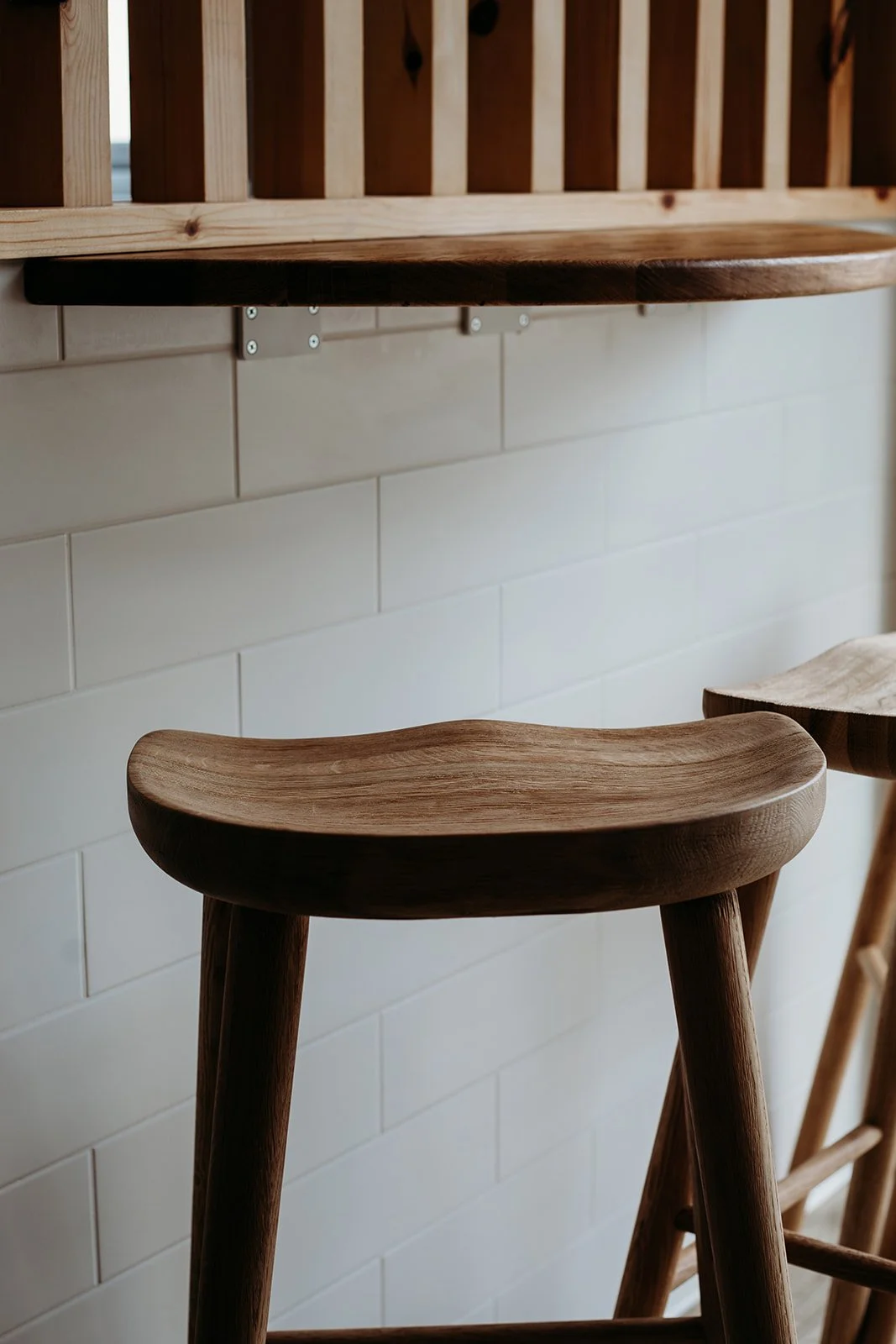 Wooden chair and shelf with white tiled wall background.