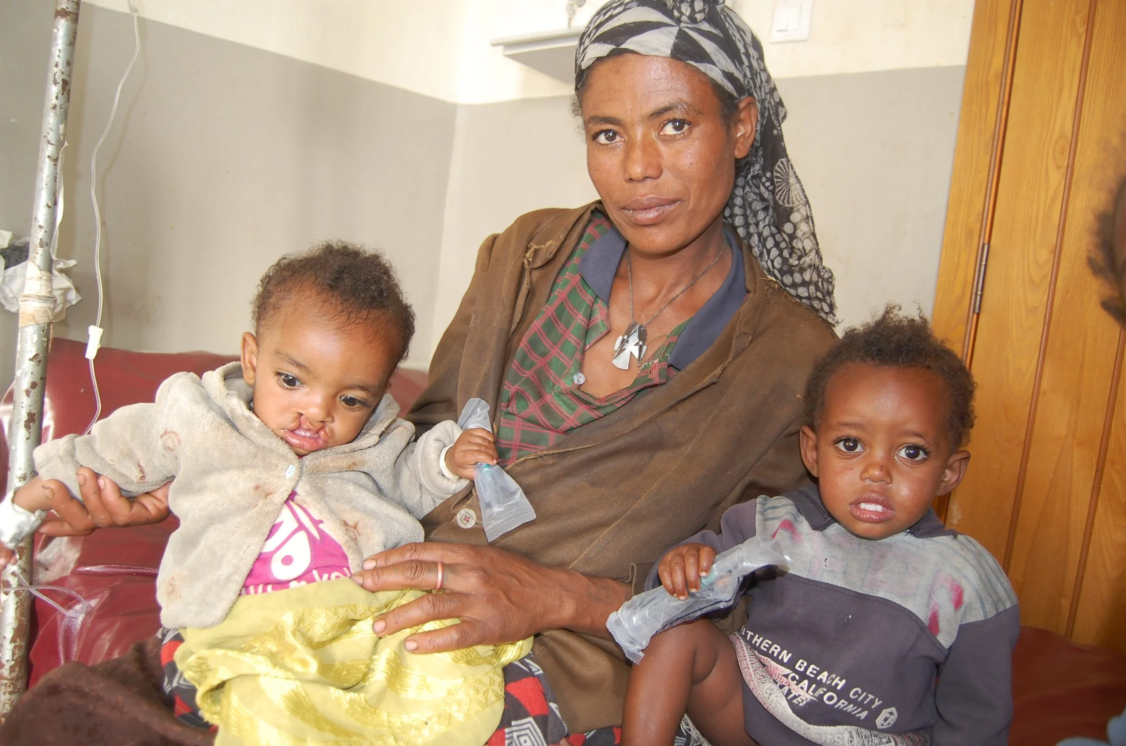 Wakjira pictured with his mother and twin brother. 