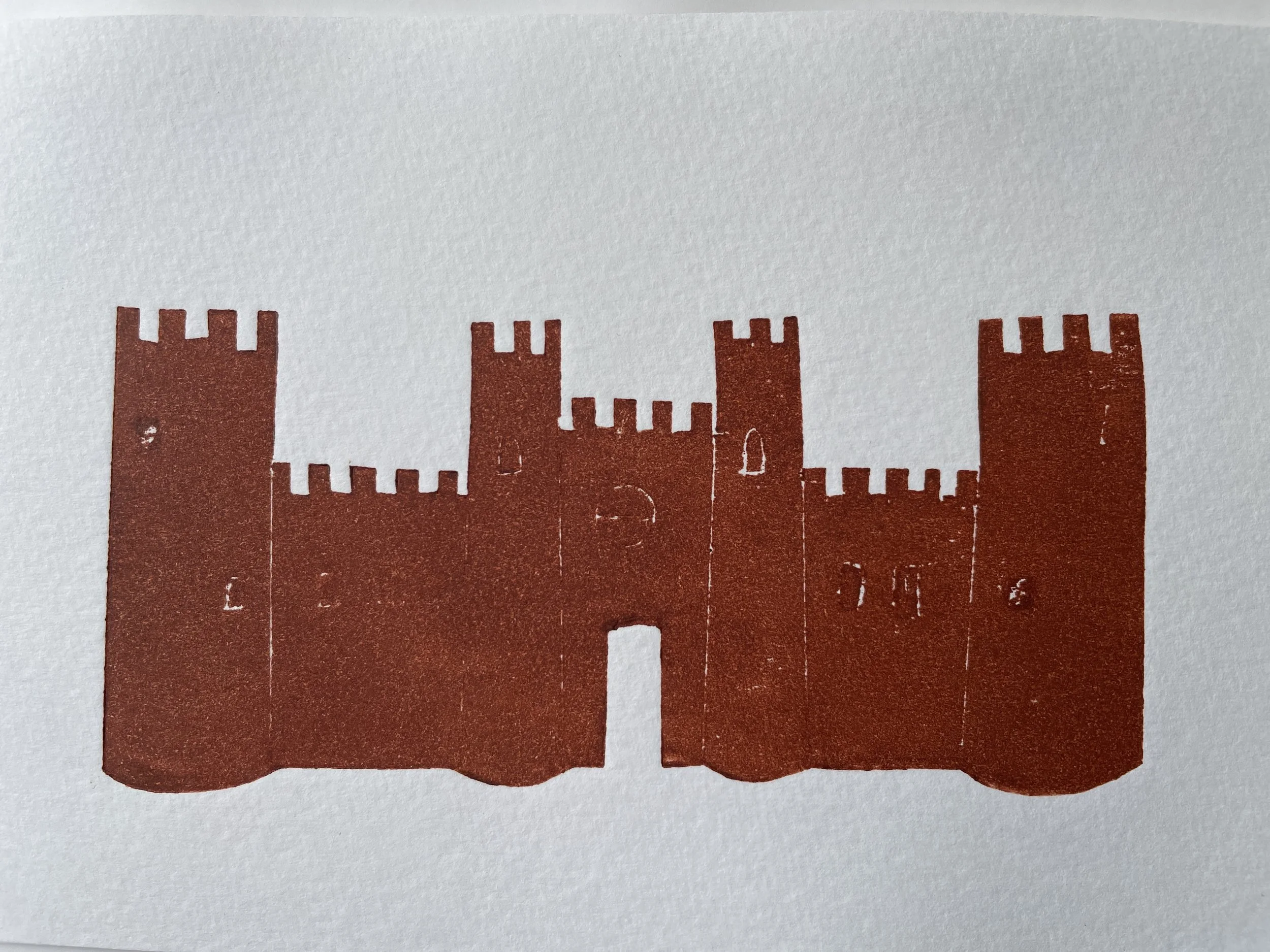 Red castle silhouette with towers and battlements on a white background.