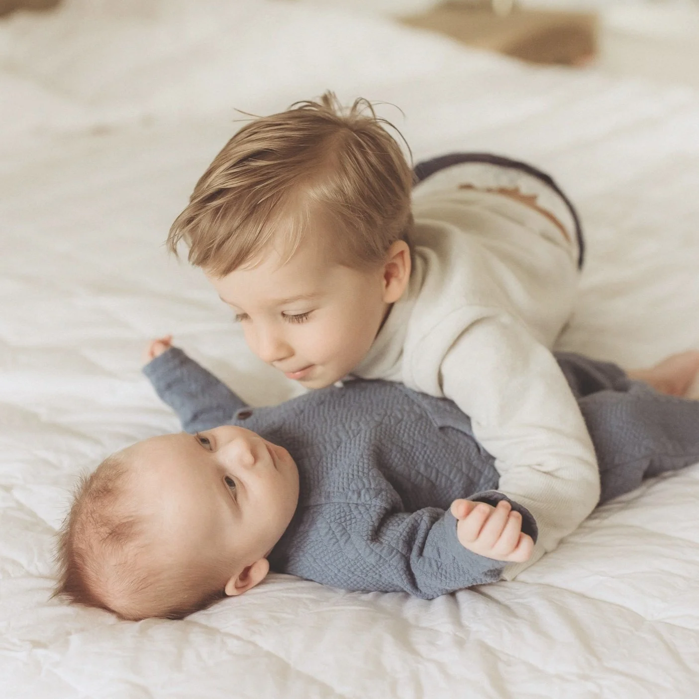 toddler and baby on bed
