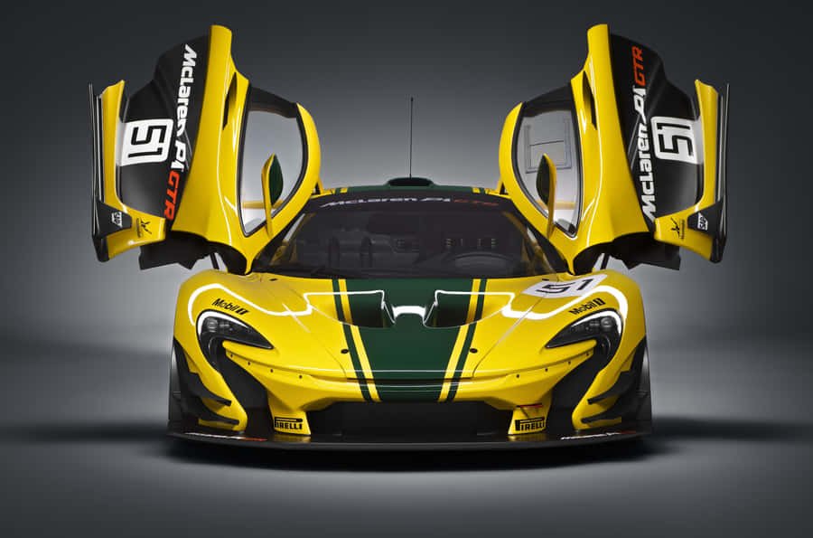 A yellow and green McLaren race car with open doors, displayed head-on with headlights, racing decals, and the number 51.