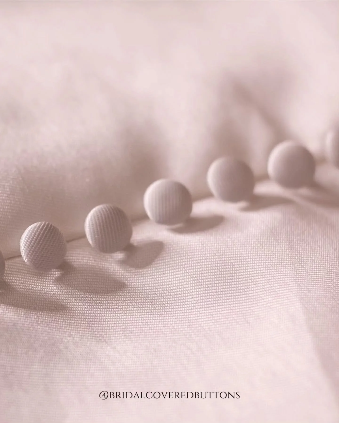 Softly shimmering in blush pink Mikado, these 11mm high dome buttons add a whisper of romance and grace to your bridal gown.

#blushpinkbuttons #mikadobuttons #coveredbuttons #bridalbuttons #handcraftedbridal #romanticdetails #madetoorder #bridaldeta