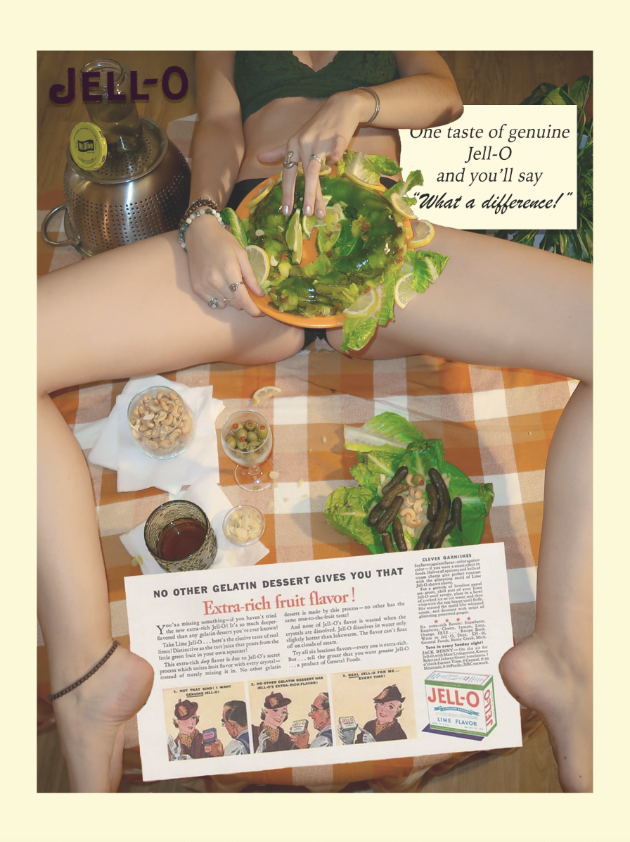 A person sitting on a checkered tablecloth around various food items and a Jell-O salad, with a pickle salad and a tea pot nearby, and promotional Jell-O advertising. The Jello salad is placed in the croch of the person and their head is not visable